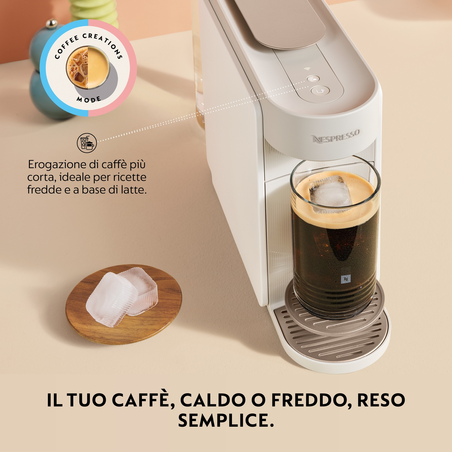 Una macchina Nespresso prepara un caffè freddo. Cubetti di ghiaccio su un vassoio di legno.