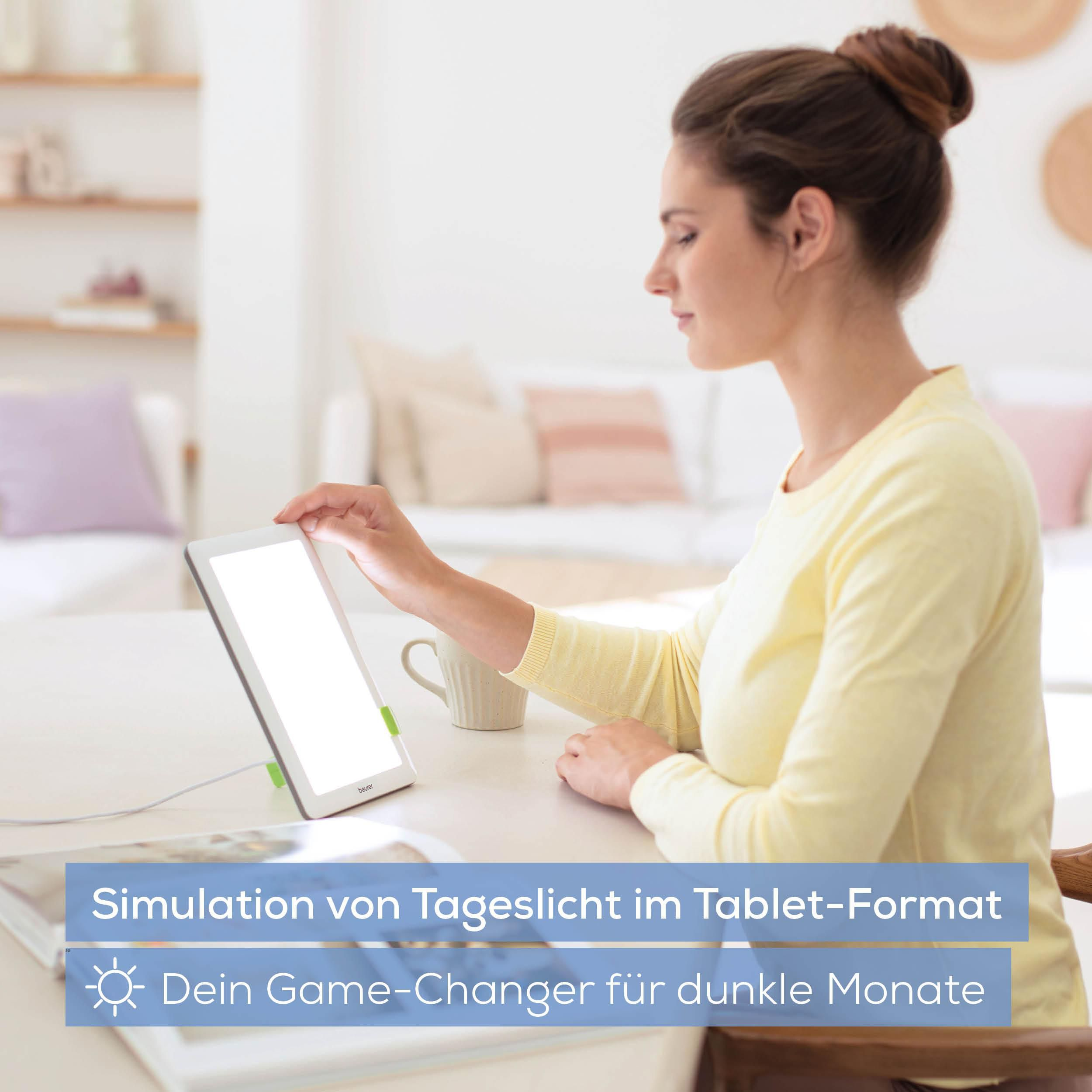 Frau mit Dutt und gelbem Pullover nutzt Lichttherapie-Tablet.