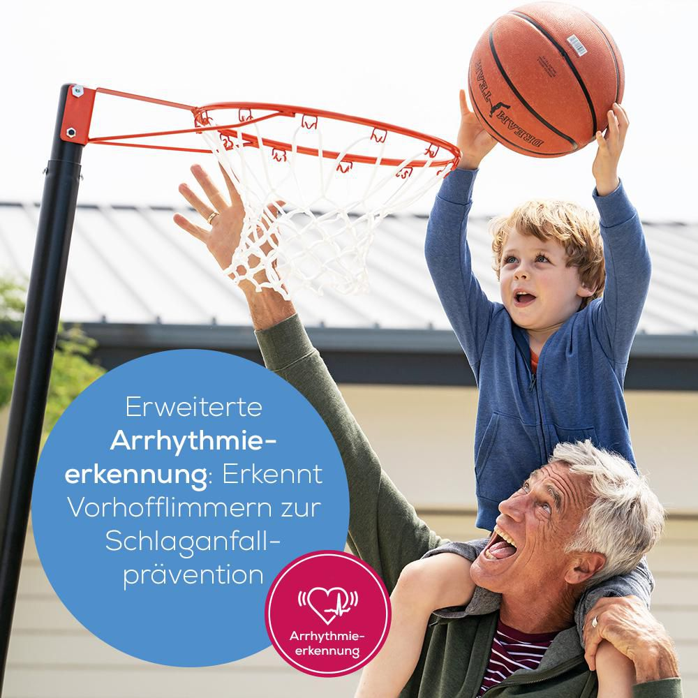 Ein Mann trägt einen Jungen auf den Schultern, der einen Basketball hält.