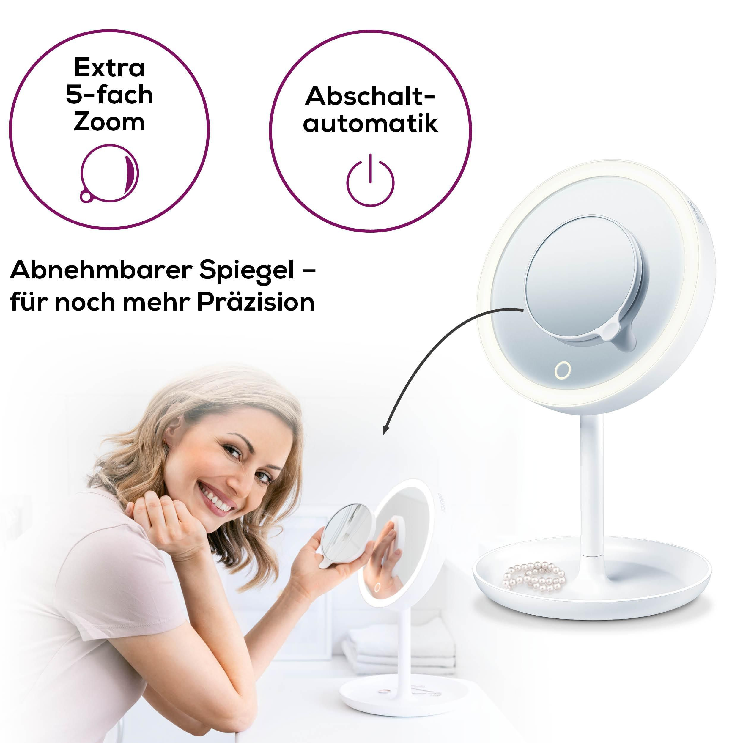 Eine Frau lächelt, während sie einen beleuchteten Kosmetikspiegel hält. Perlen liegen im Sockel.