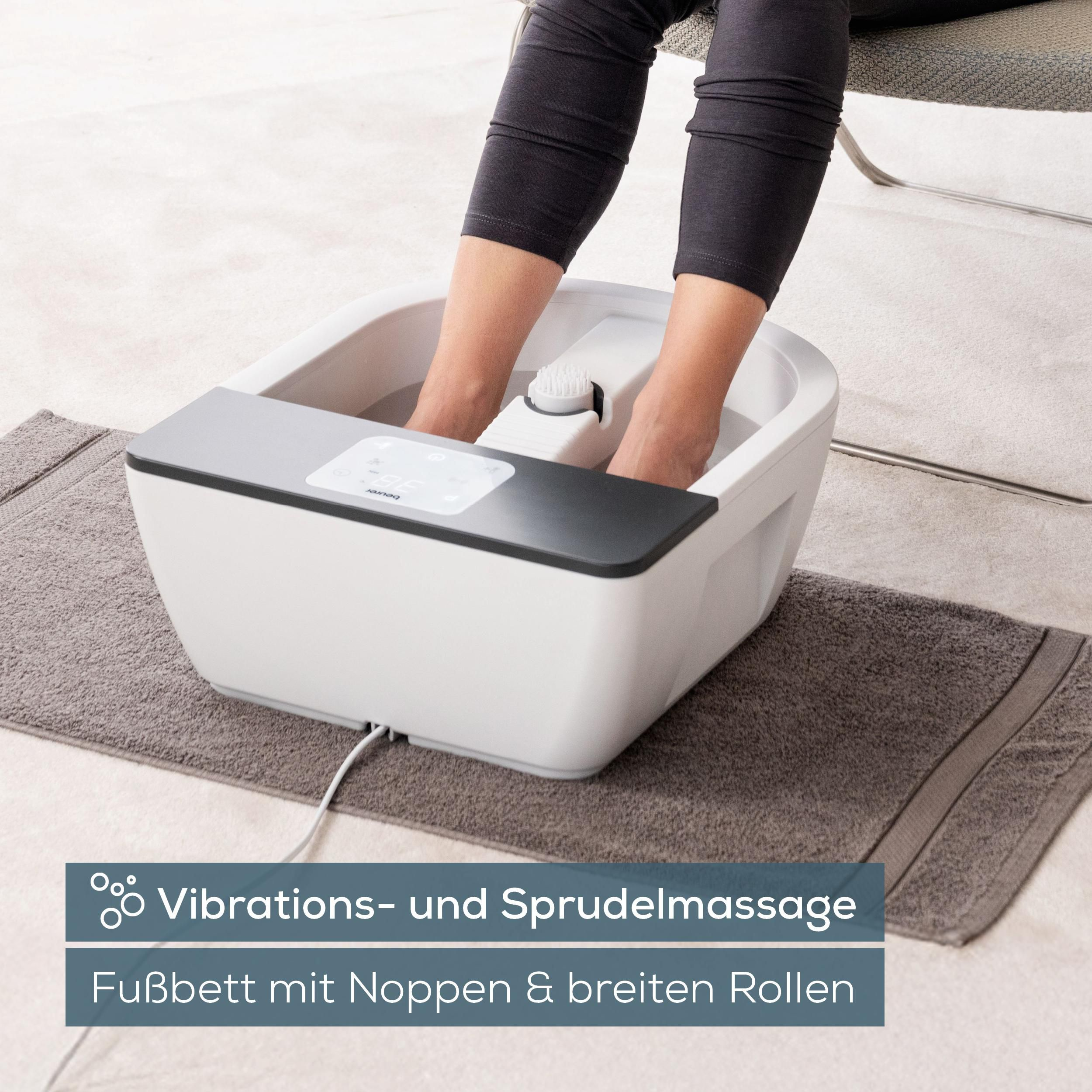 Füße in einem Fußbad mit Sprudelmassage und Vibrationsfunktion.