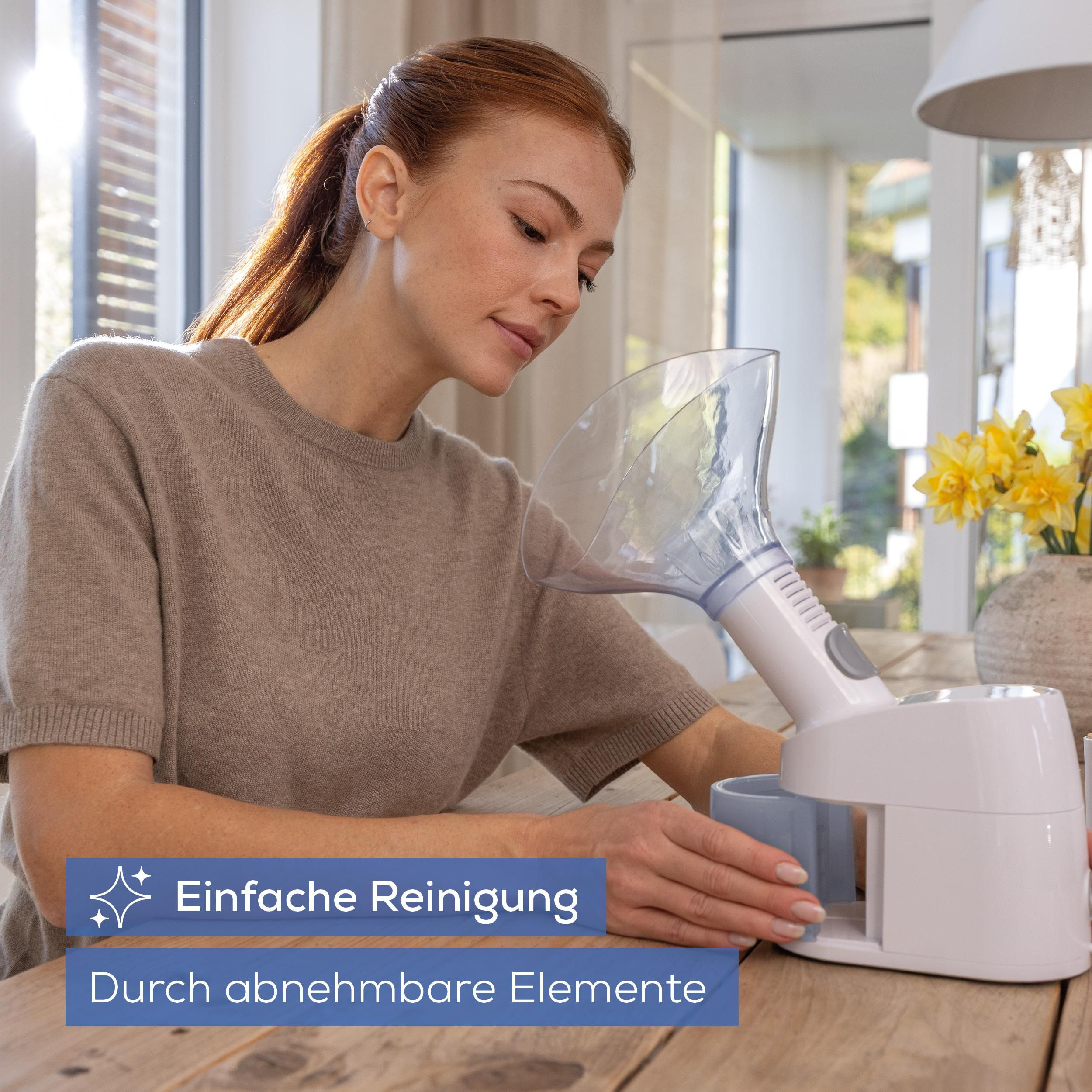 Eine Frau mit roten Haaren benutzt einen weißen Inhalator mit klarem Aufsatz.