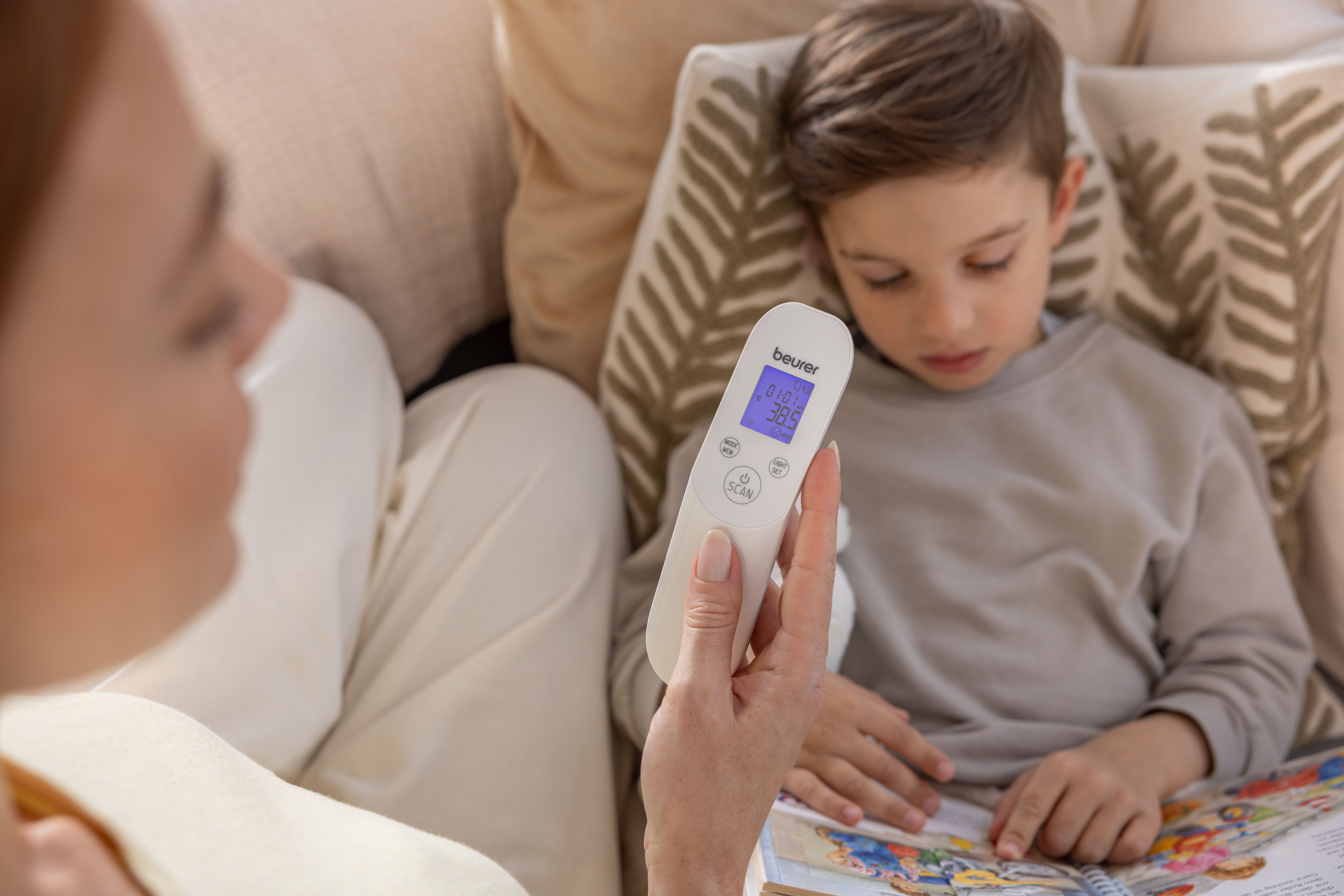 Eine Person misst die Temperatur eines Kindes mit einem digitalen Thermometer.
