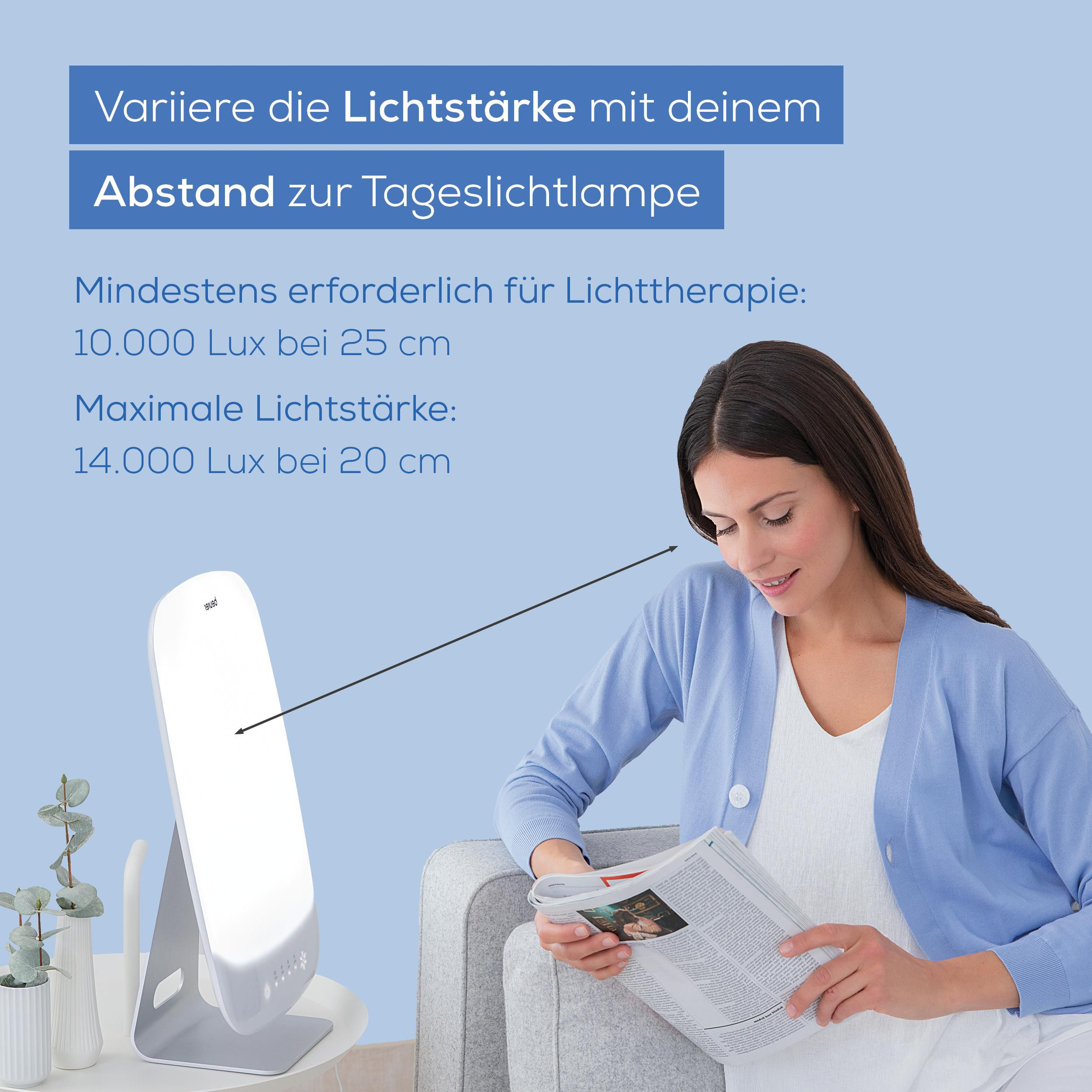 Frau liest Zeitung neben Lichttherapie-Lampe. Abstand ist wichtig für Lichttherapie.