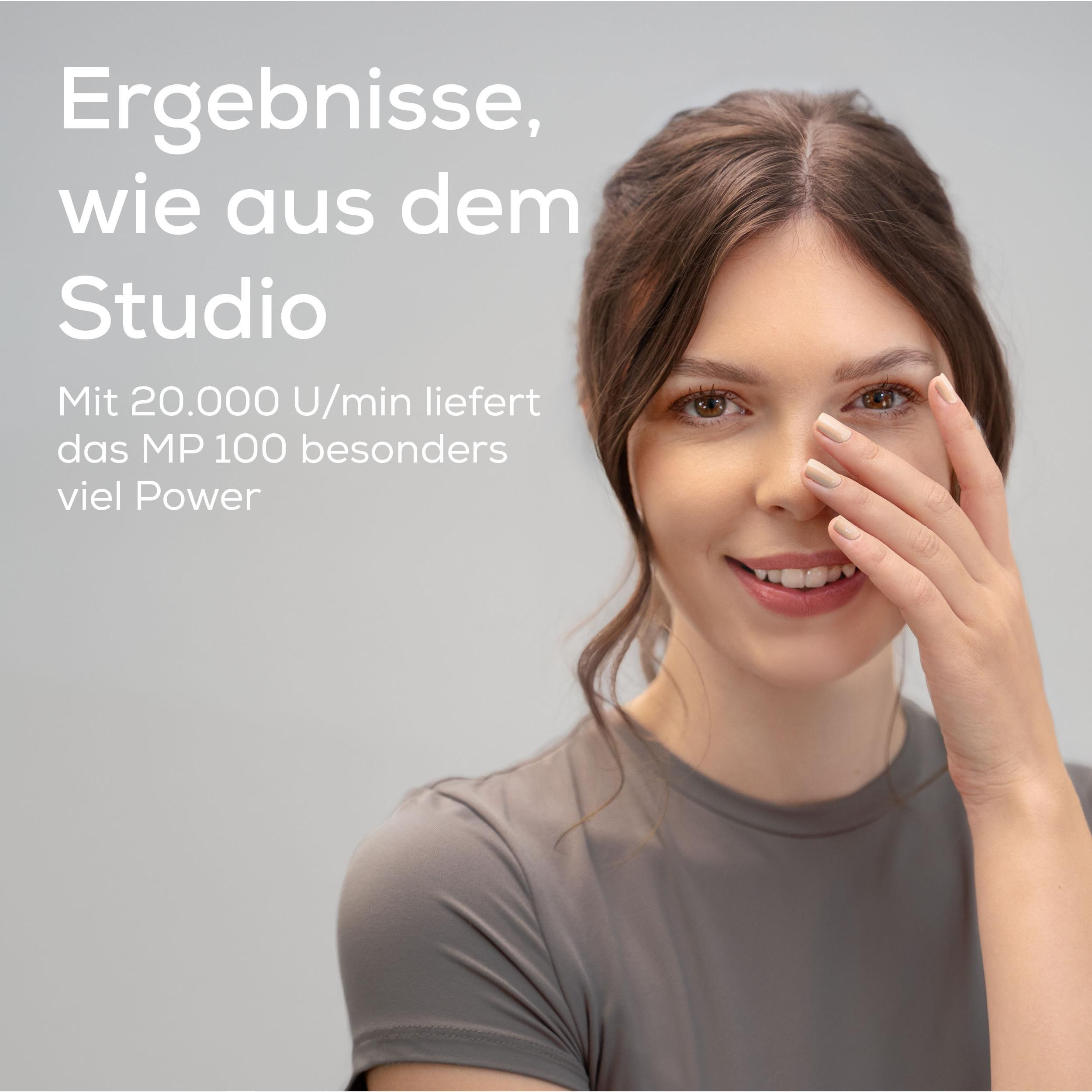 Frau mit braunen Haaren und graublauem Oberteil, die Hand vor dem Gesicht.