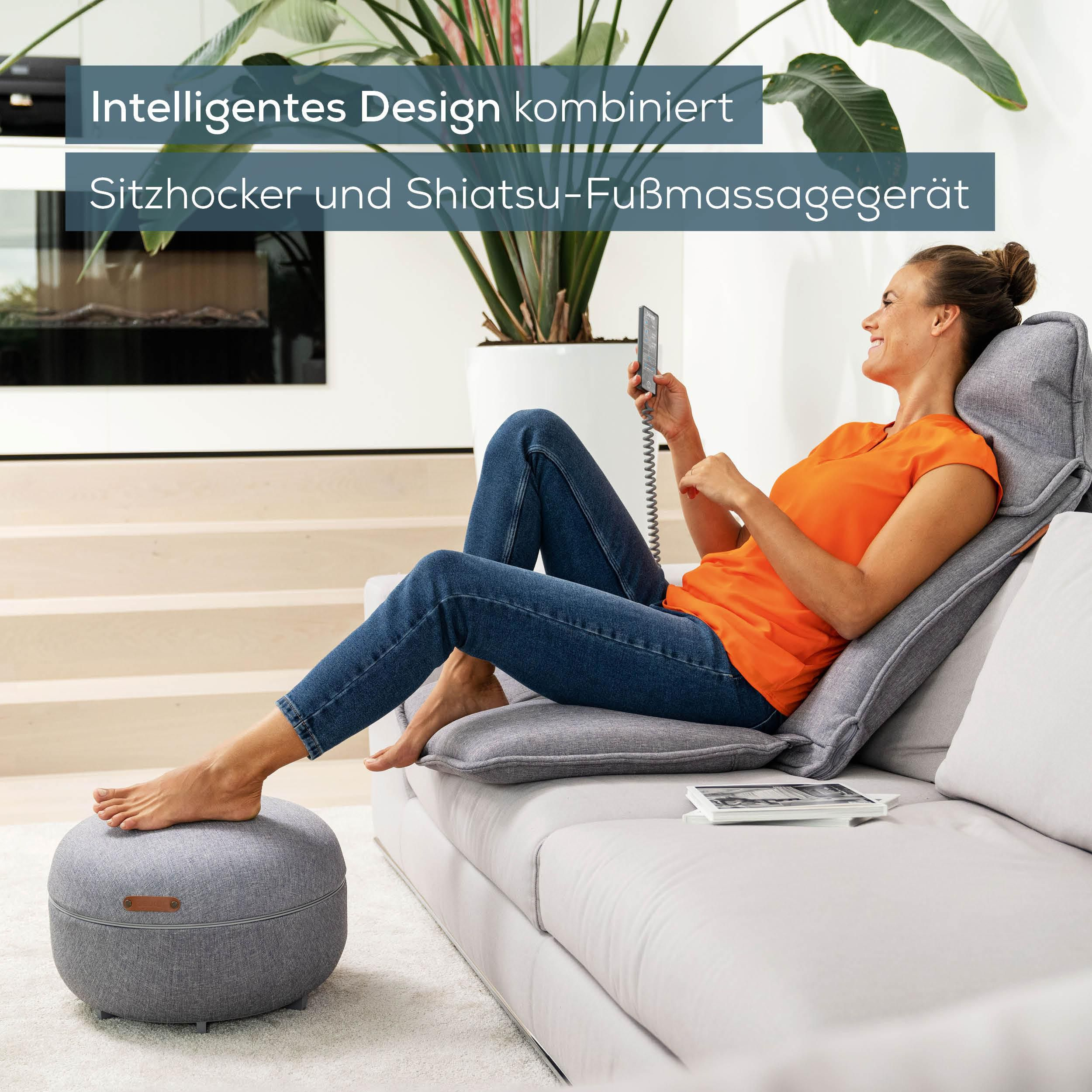 Frau entspannt auf Sofa mit Fußhocker und Fernbedienung.