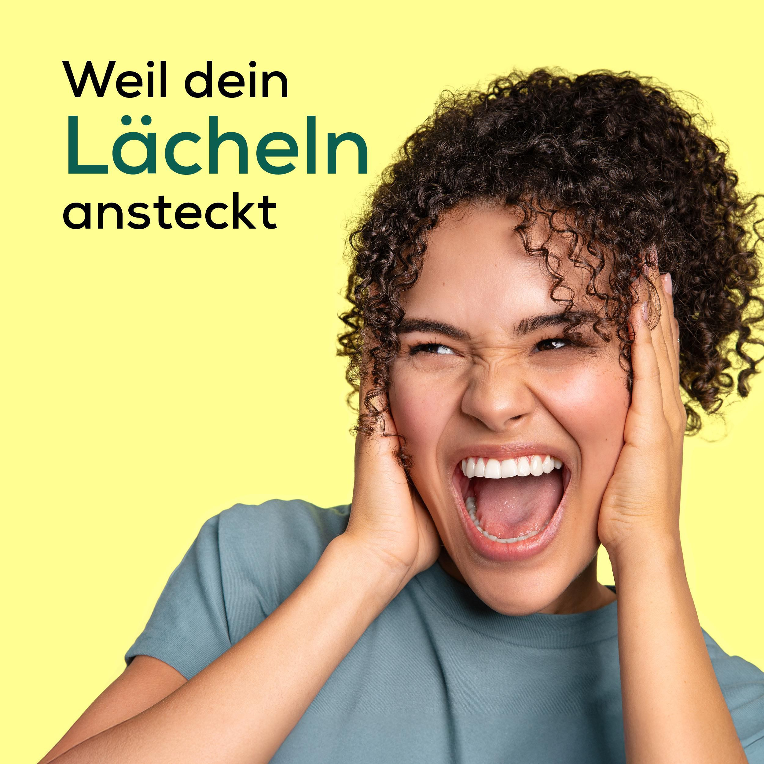 Junge Frau mit lockigem Haar schreit mit weit geöffnetem Mund und hält sich die Ohren zu.