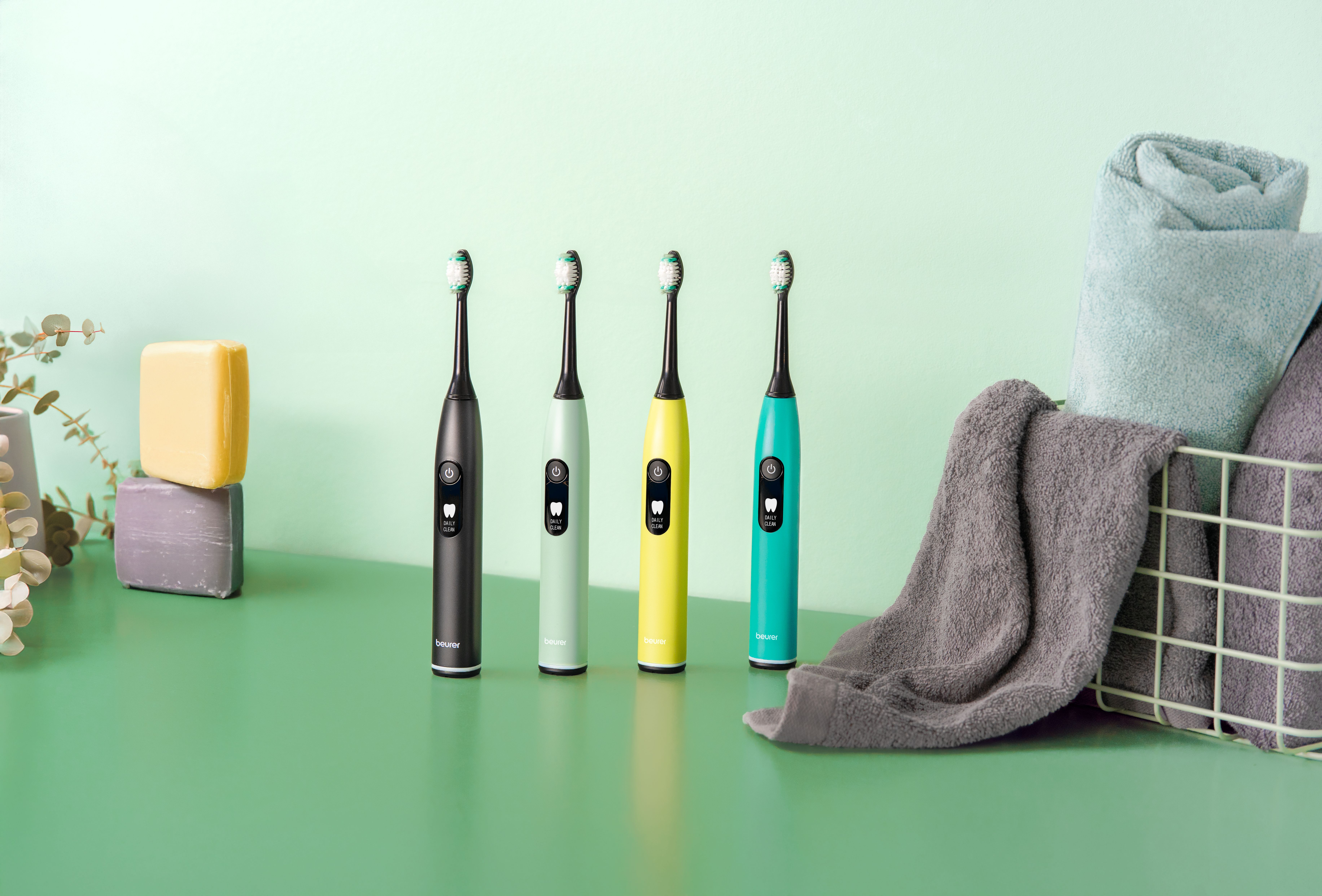 Vier elektrische Zahnbürsten in Schwarz, Mint, Gelb und Türkis.