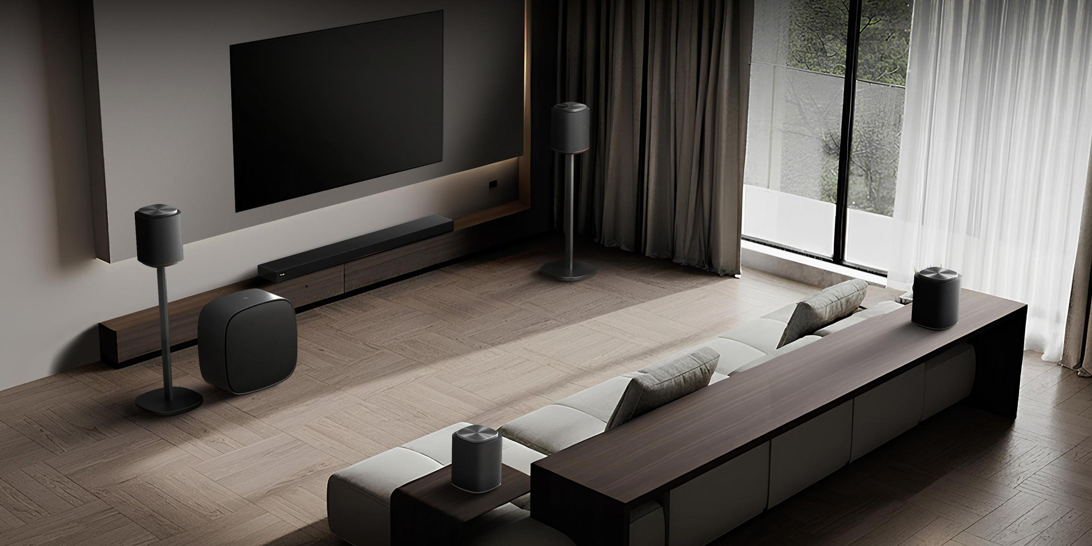 Ein stilvolles Wohnzimmer mit Fernseher, Sofa und mehreren Lautsprechern.