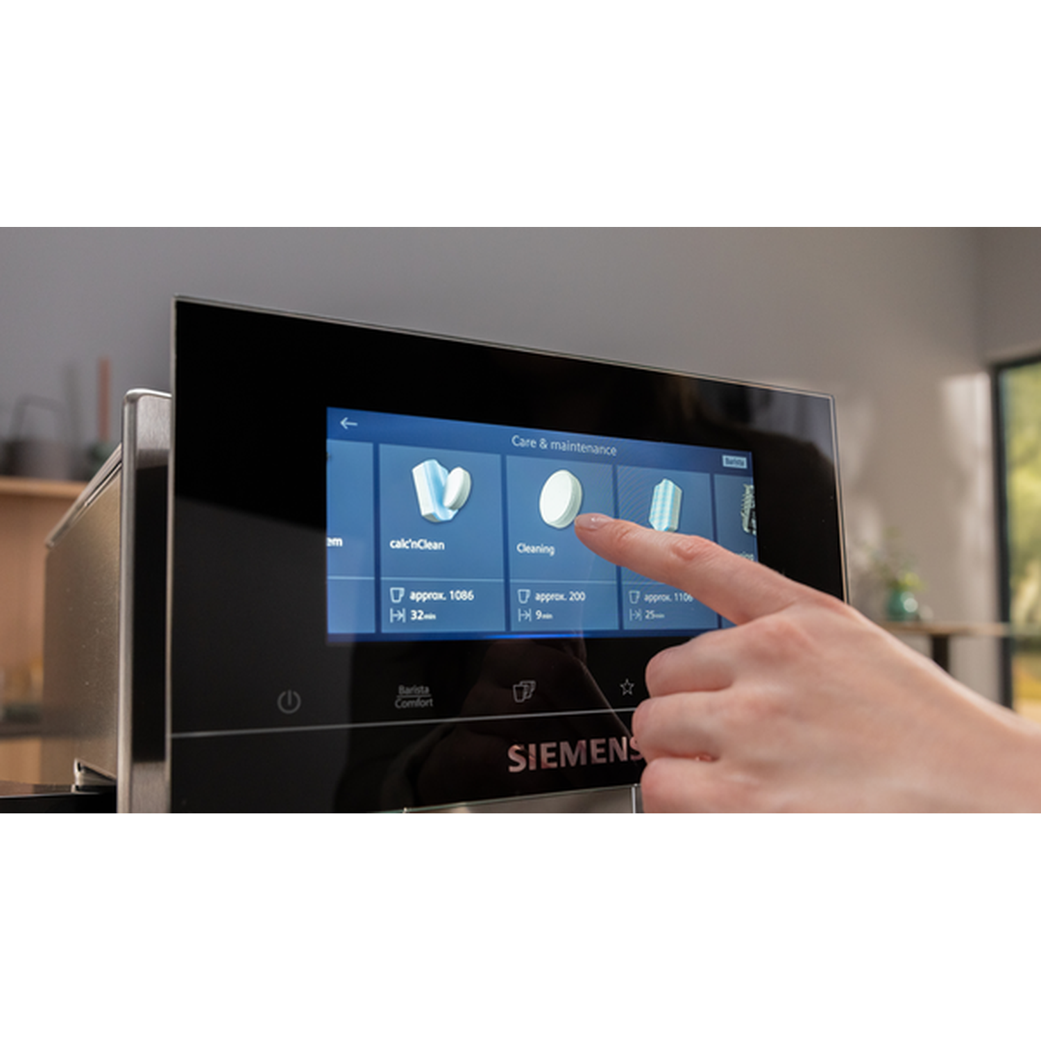 A hand touches the touchscreen of a Siemens coffee machine in the maintenance menu.