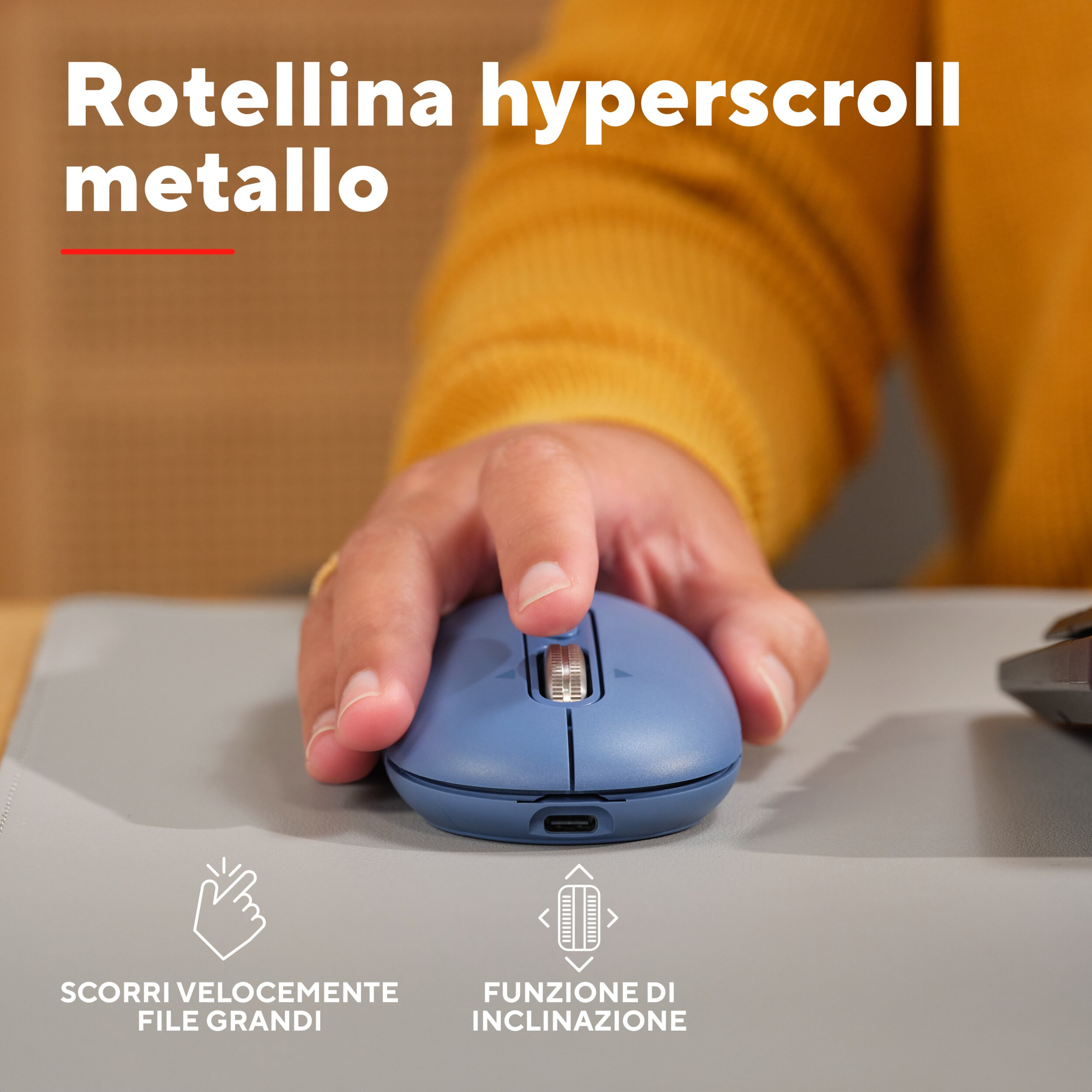 Mouse blu con rotellina in metallo, tenuto dalla mano, su superficie grigia.