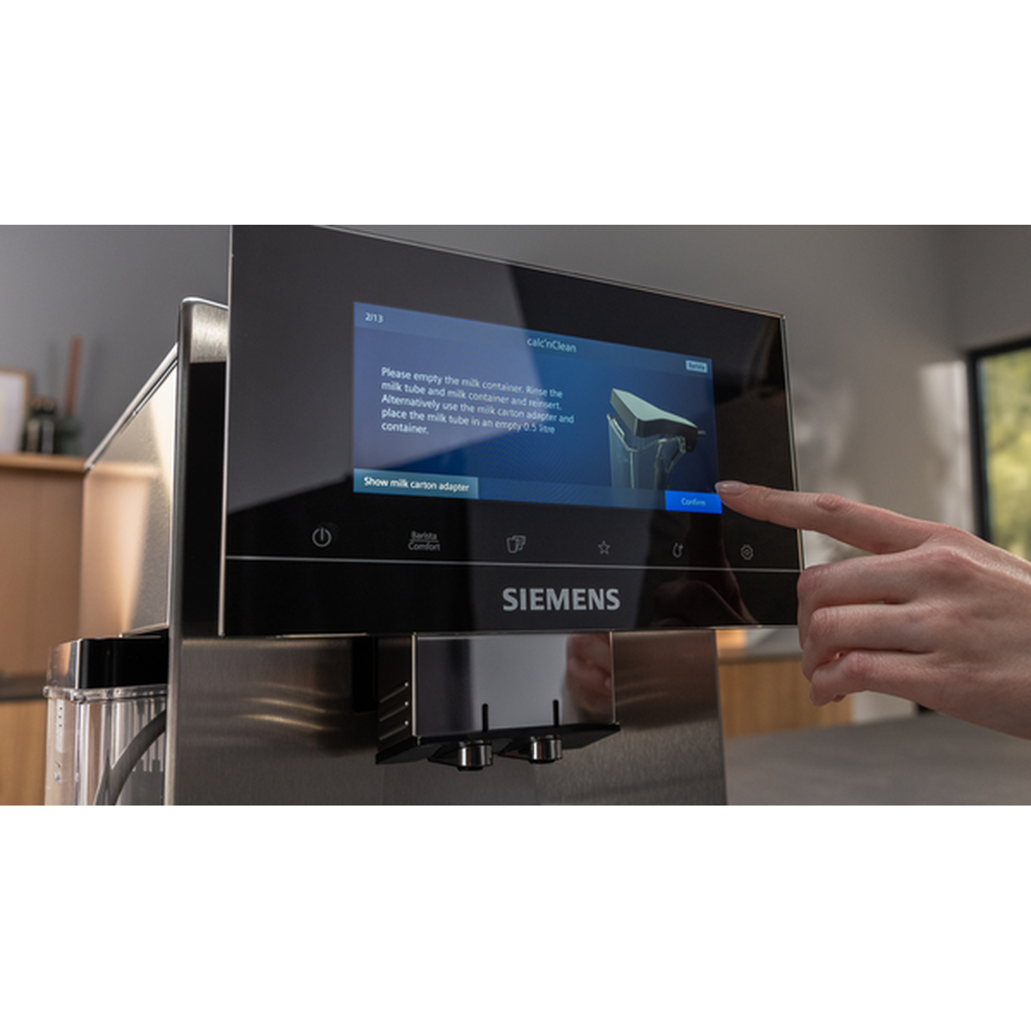 A hand presses the screen of a Siemens coffee machine to start the "calc'nClean" process.