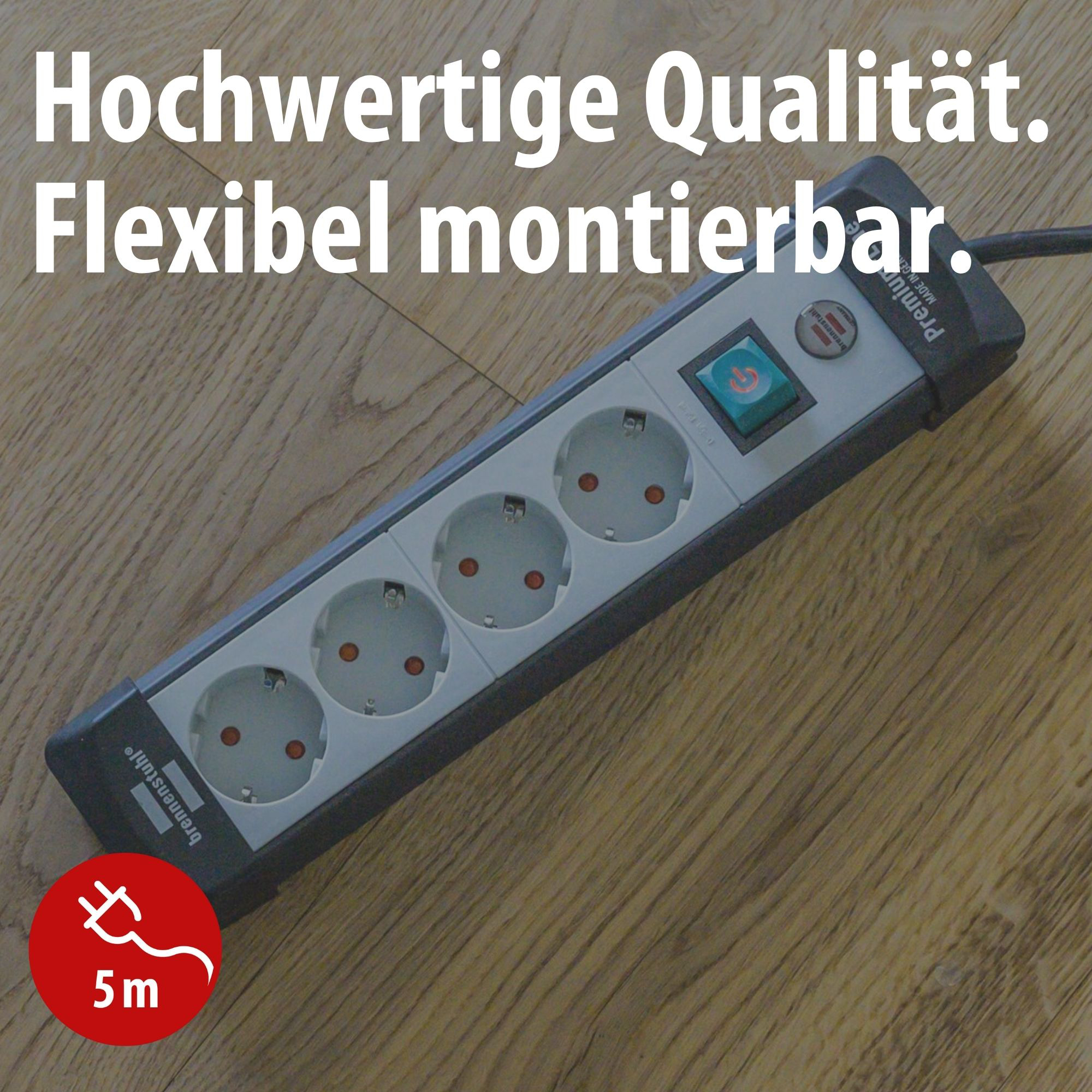 Eine graue Steckdosenleiste mit 4 Steckplätzen liegt auf Holzboden.