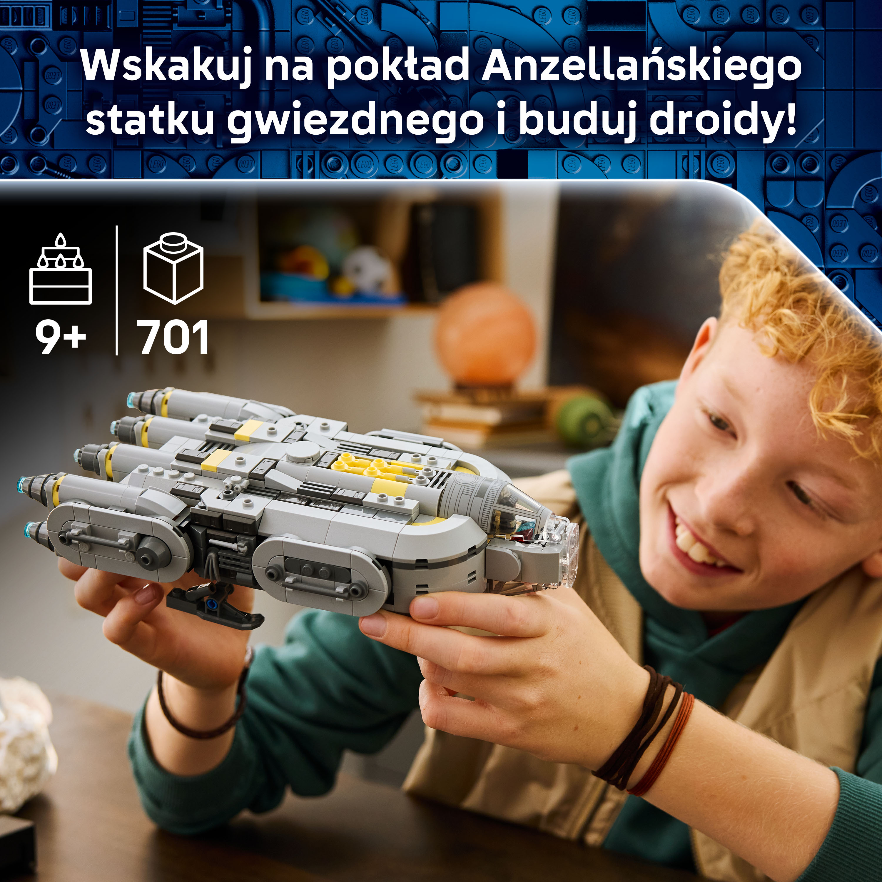 Chłopiec trzyma szary statek kosmiczny Lego z żółtymi akcentami.