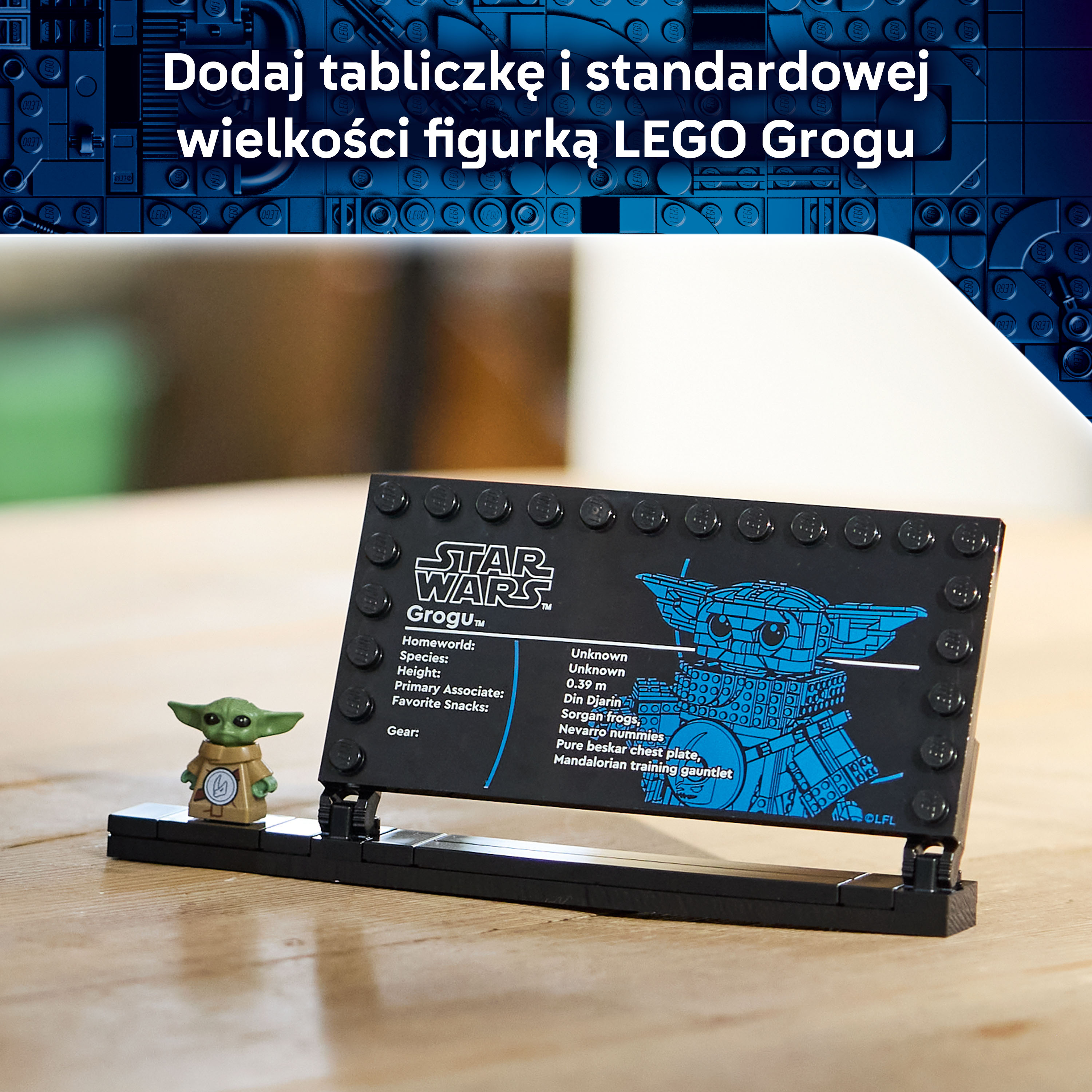 Figurka LEGO Grogu obok tabliczki informacyjnej Star Wars na drewnianej powierzchni.
