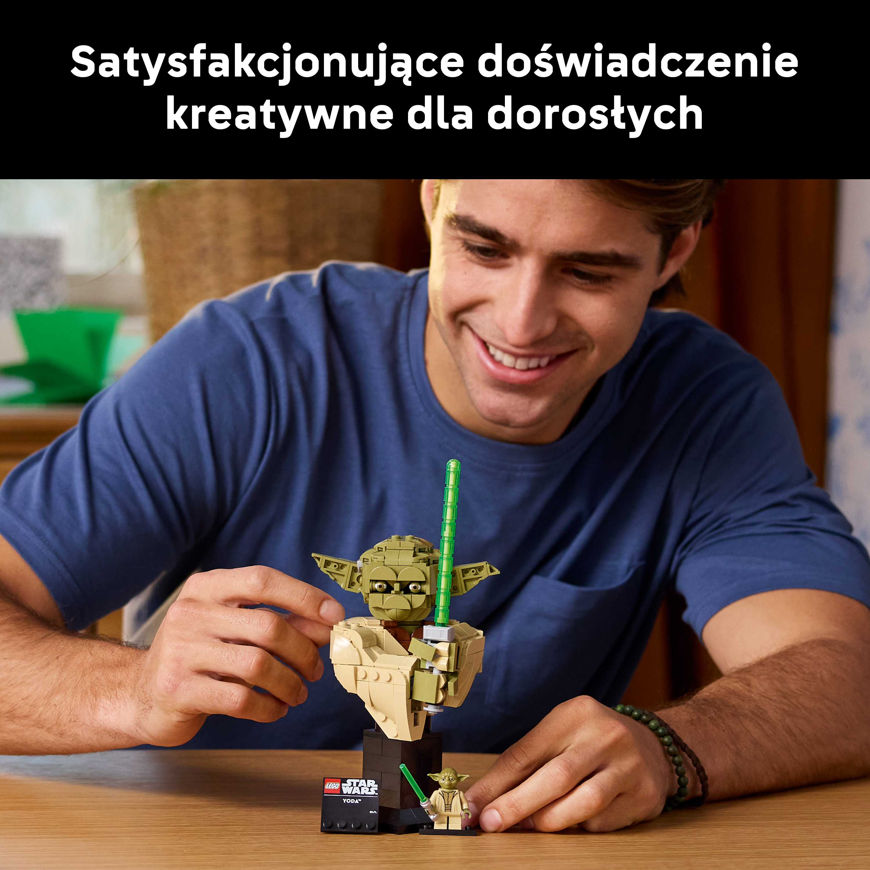 Mężczyzna buduje figurkę Lego Yody. Stół i tło są rozmyte.