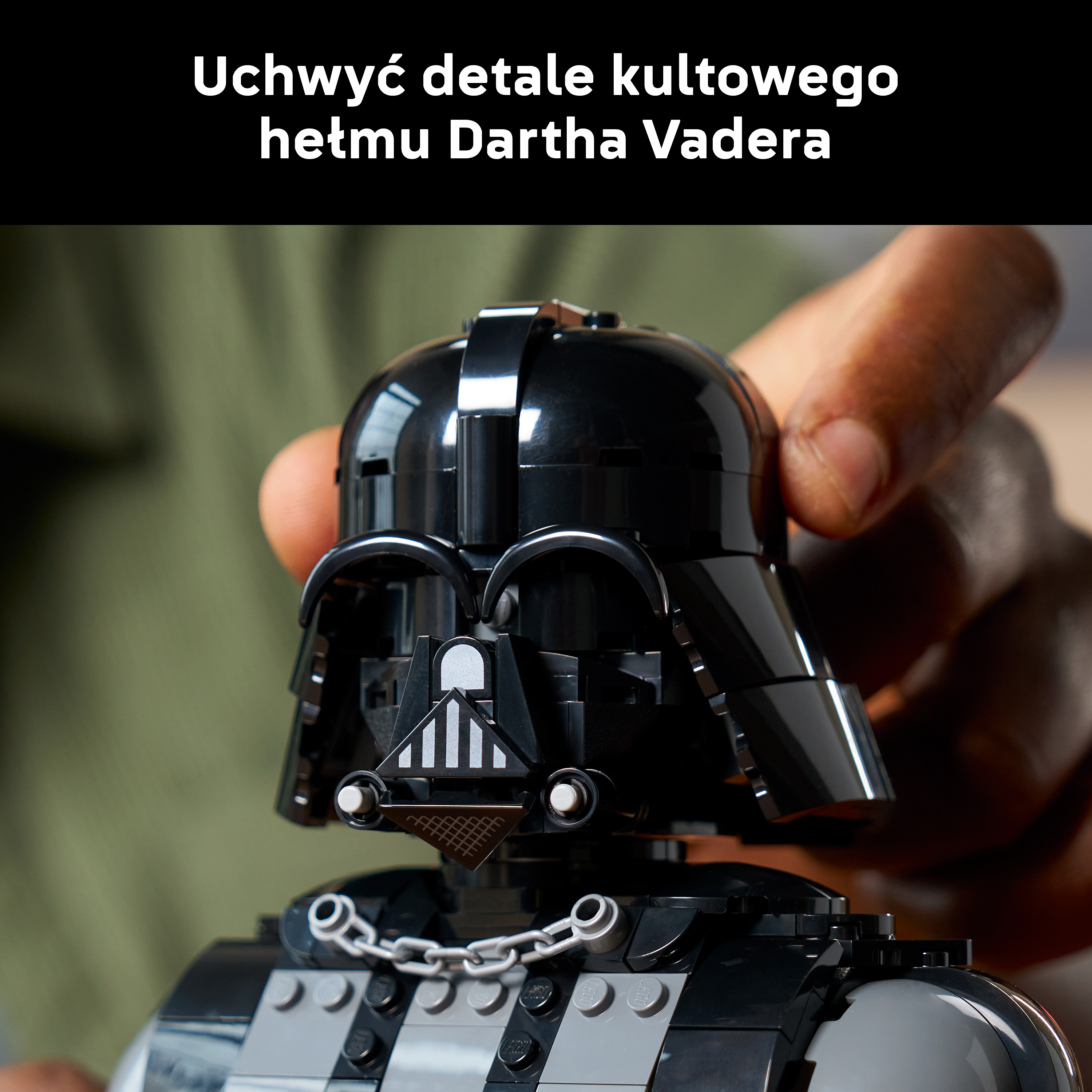 Model kasku Dartha Vadera z Lego, trzymany przez rękę.