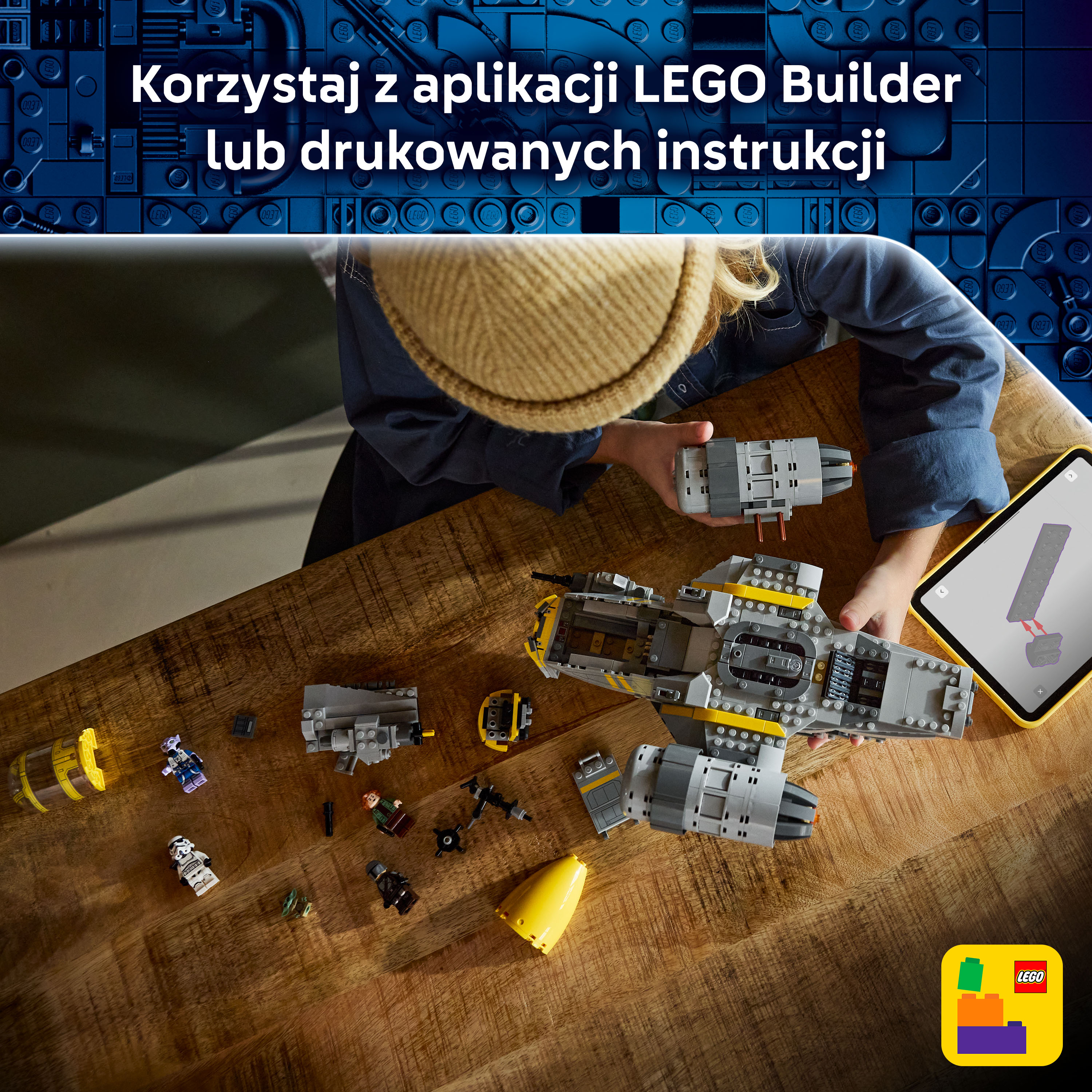 Dziecko buduje szary statek kosmiczny z klocków LEGO na drewnianym stole.