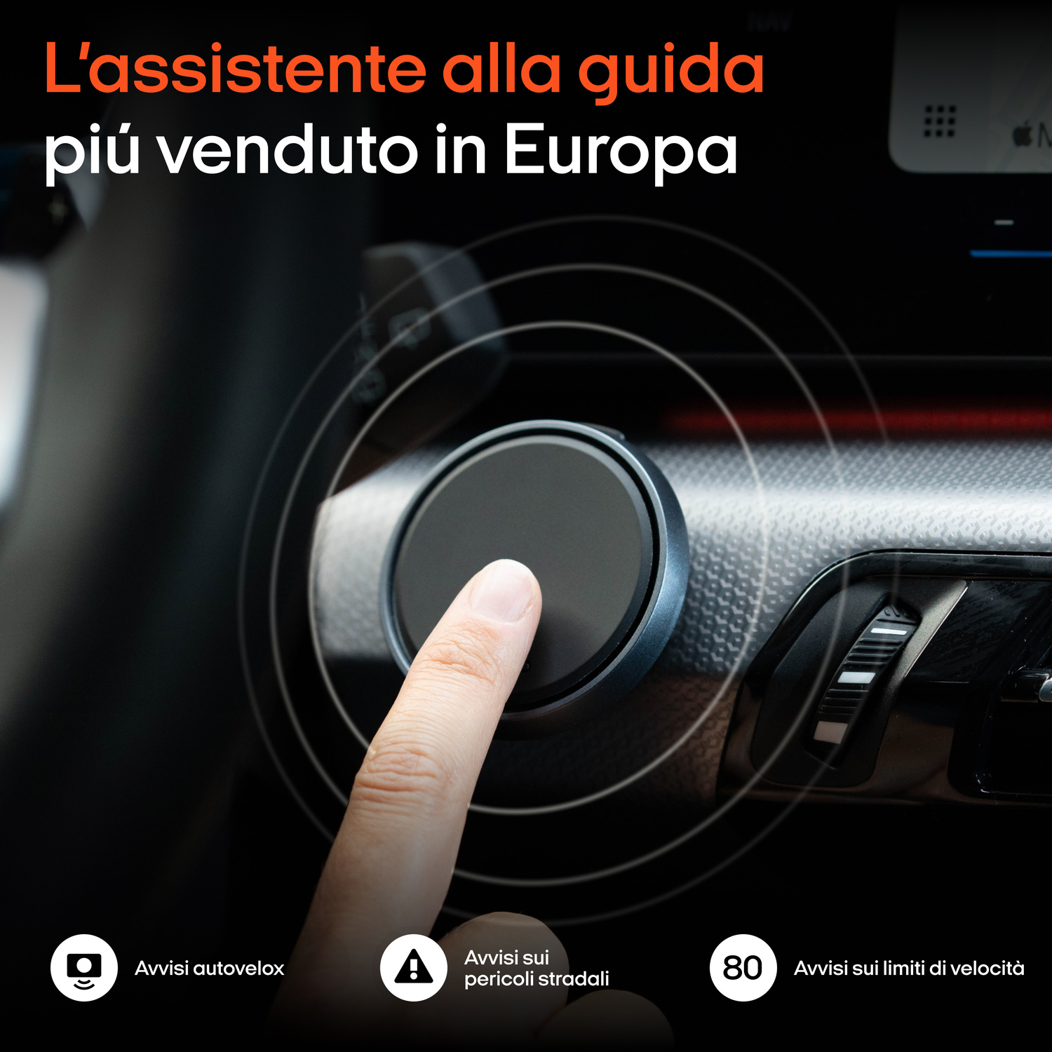 Un dito tocca un pulsante rotondo nero in auto. Avvisi autovelox e limiti di velocità.