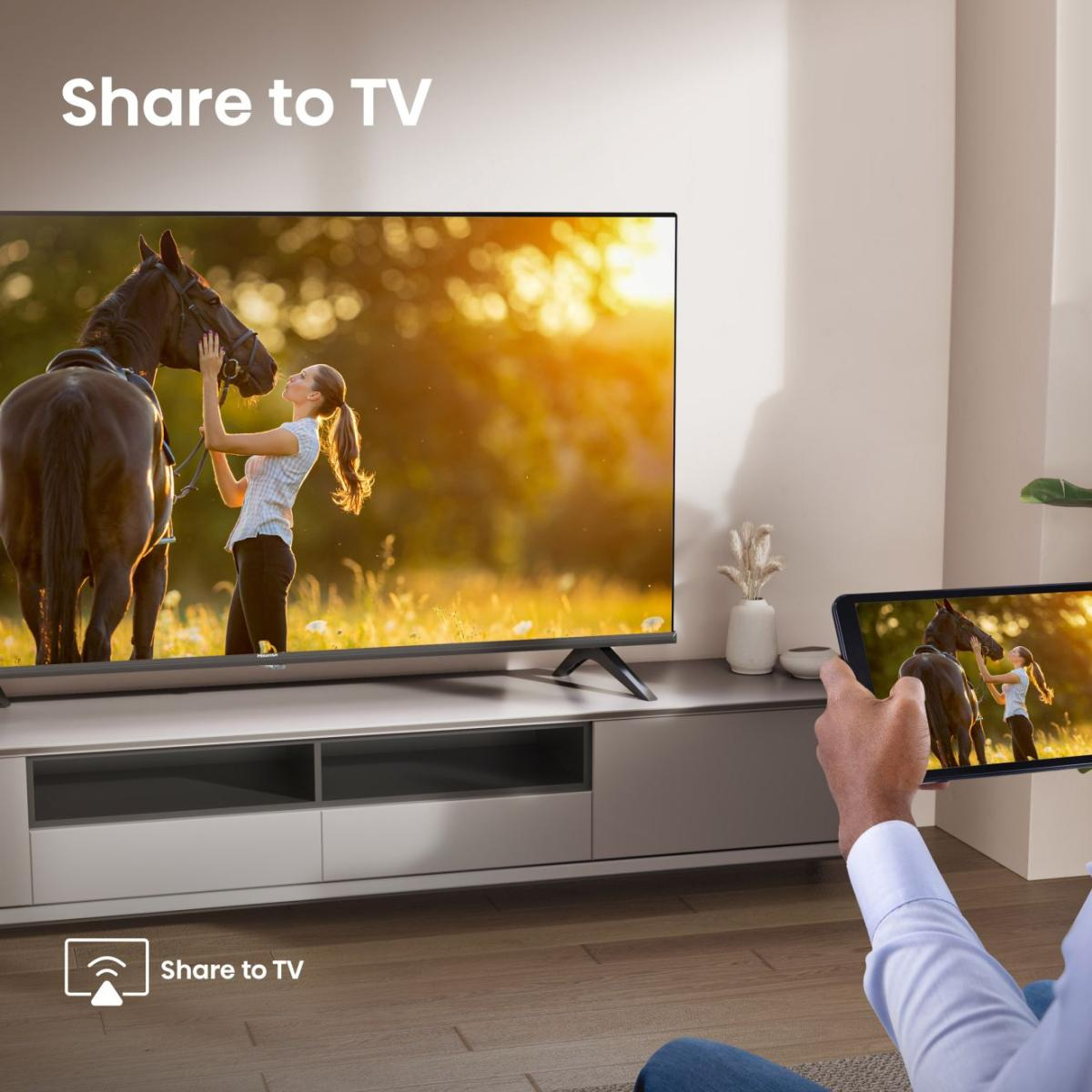 Mężczyzna udostępnia obraz konia i kobiety na tablecie na ekran telewizora.