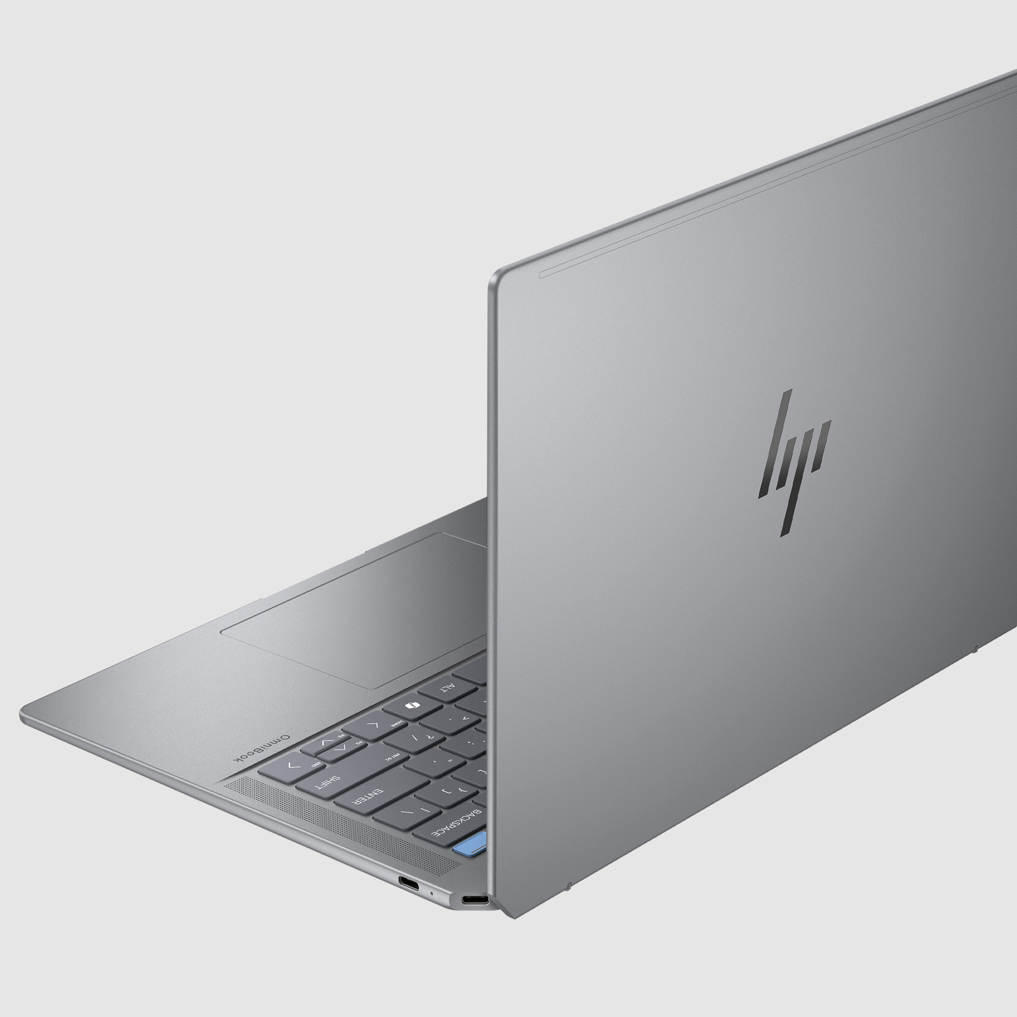 Srebrny laptop HP z podświetlaną klawiaturą i logo HP.