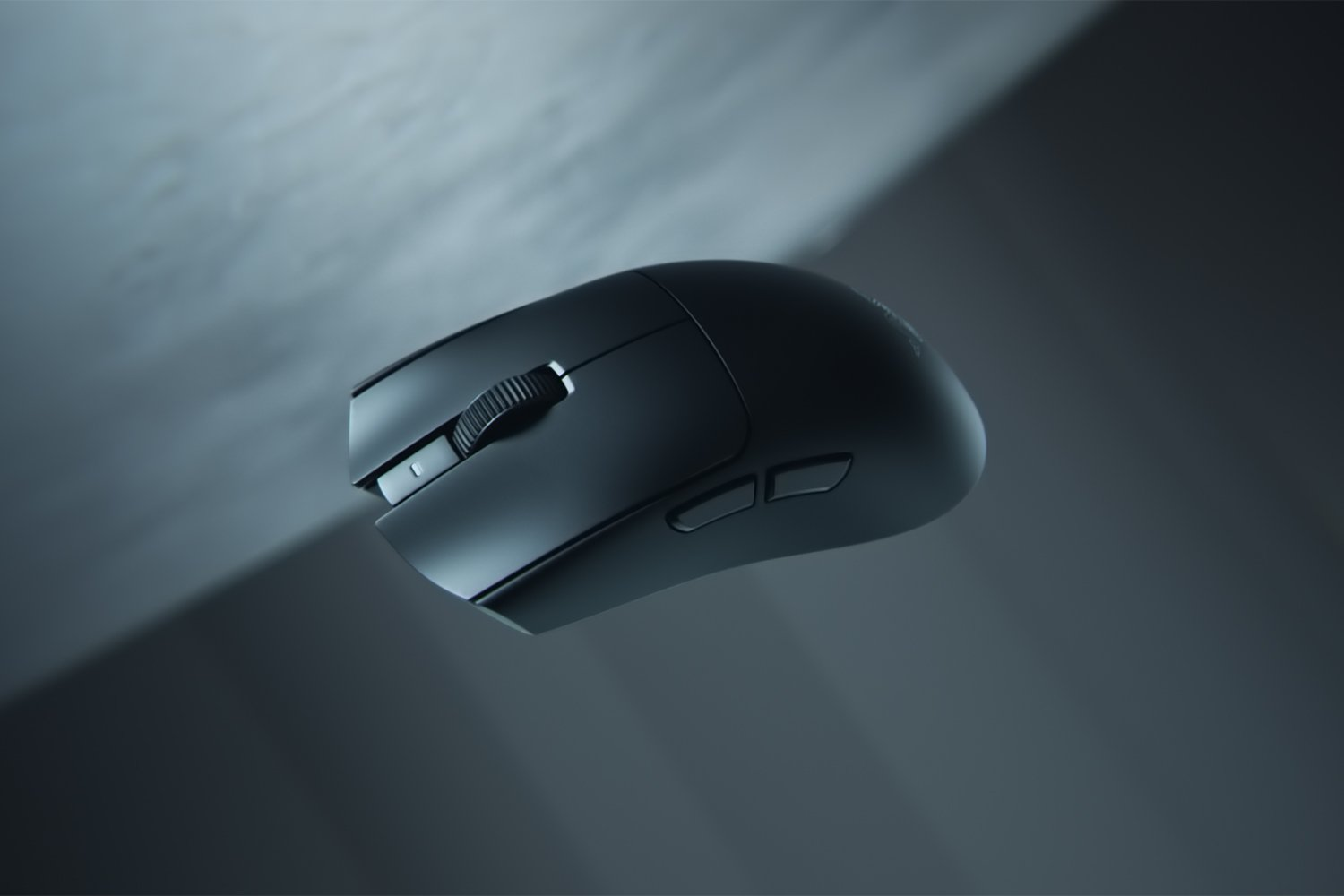 Un mouse wireless nero con rotellina e pulsanti su sfondo scuro.
