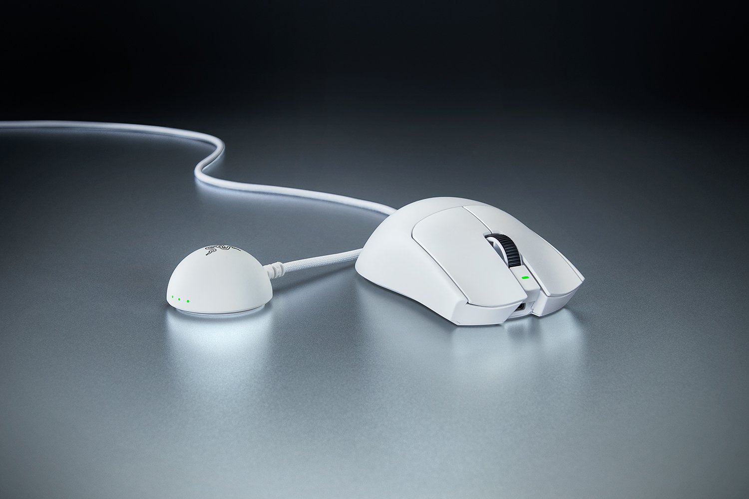 Un mouse da gioco bianco con cavo e adattatore di ricarica su una scrivania.