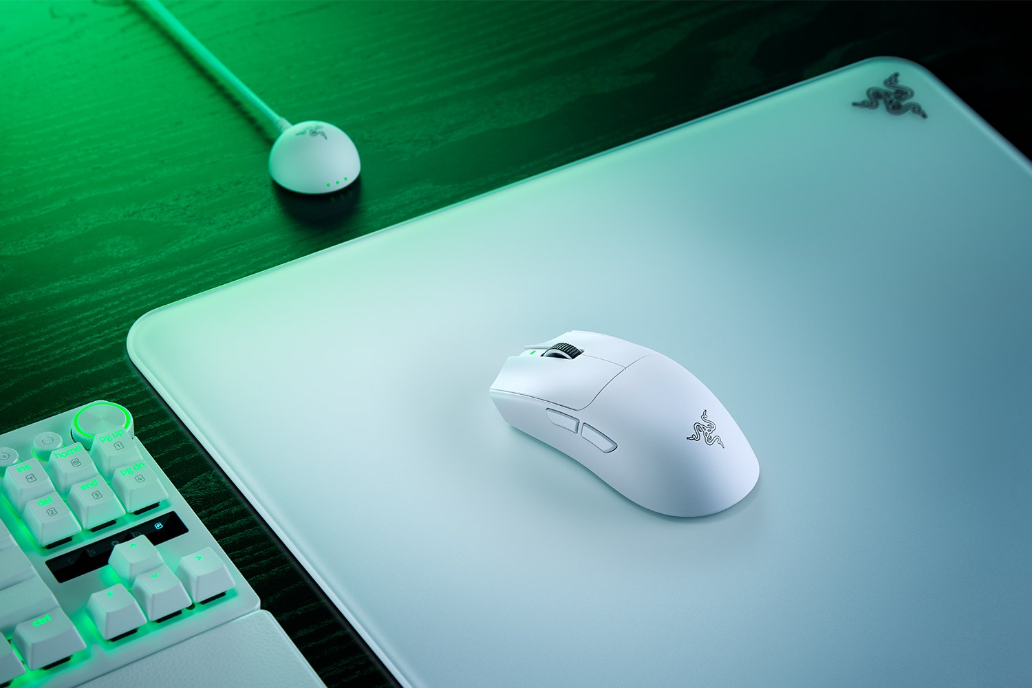 Un mouse bianco poggia su un tappetino bianco. Una tastiera è visibile a sinistra.
