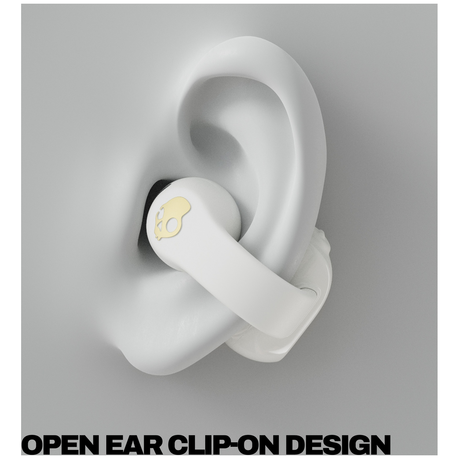 Un écouteur blanc avec logo tête de mort dorée est placé dans une oreille stylisée.