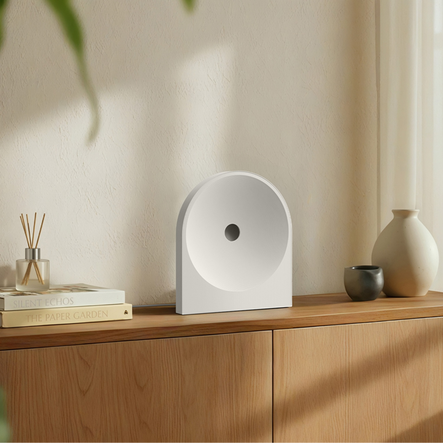 Un oggetto decorativo bianco si trova su un mobile in legno con libri e vasi.