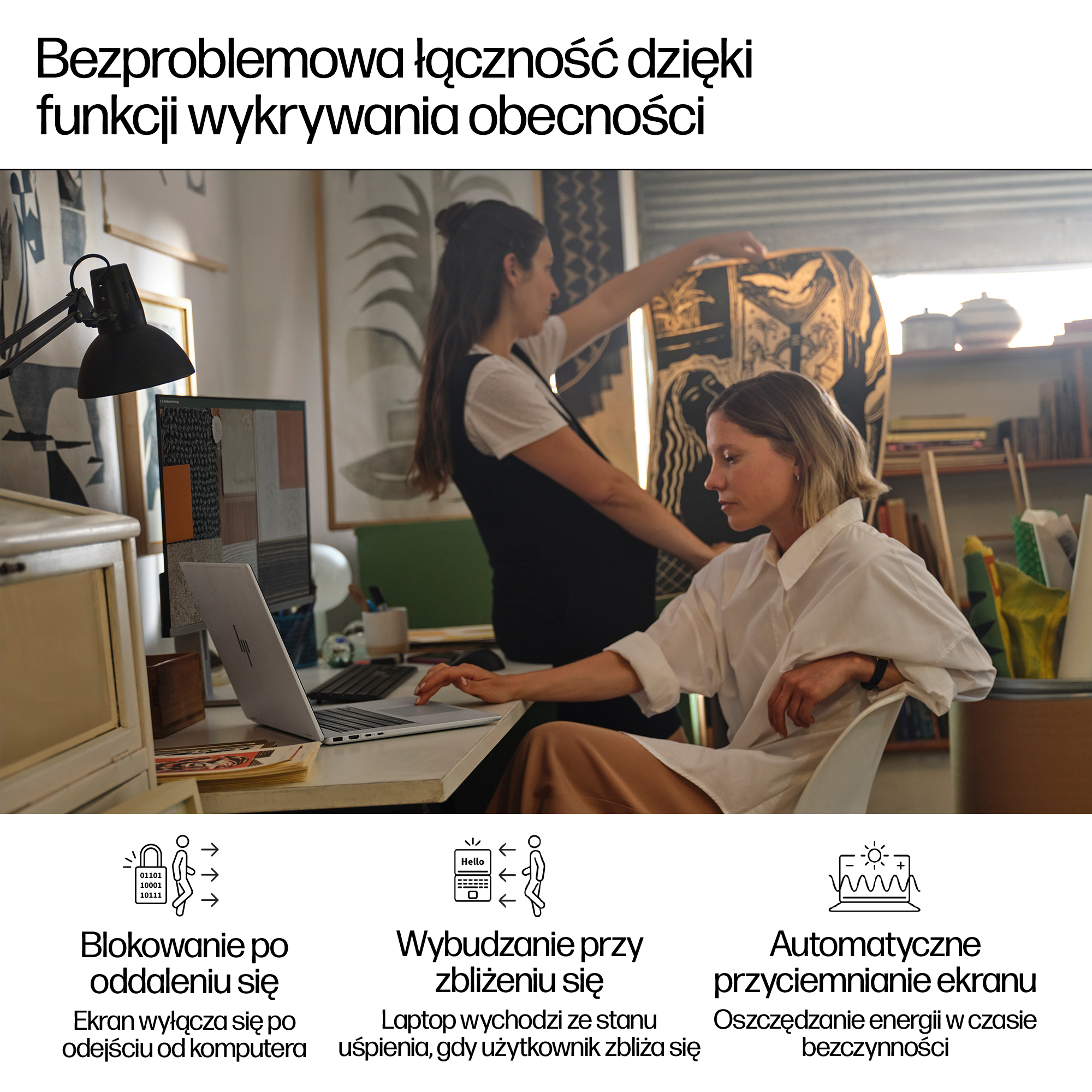 Dwie kobiety pracują przy laptopie w jasnym biurze ze sztuką na ścianach.