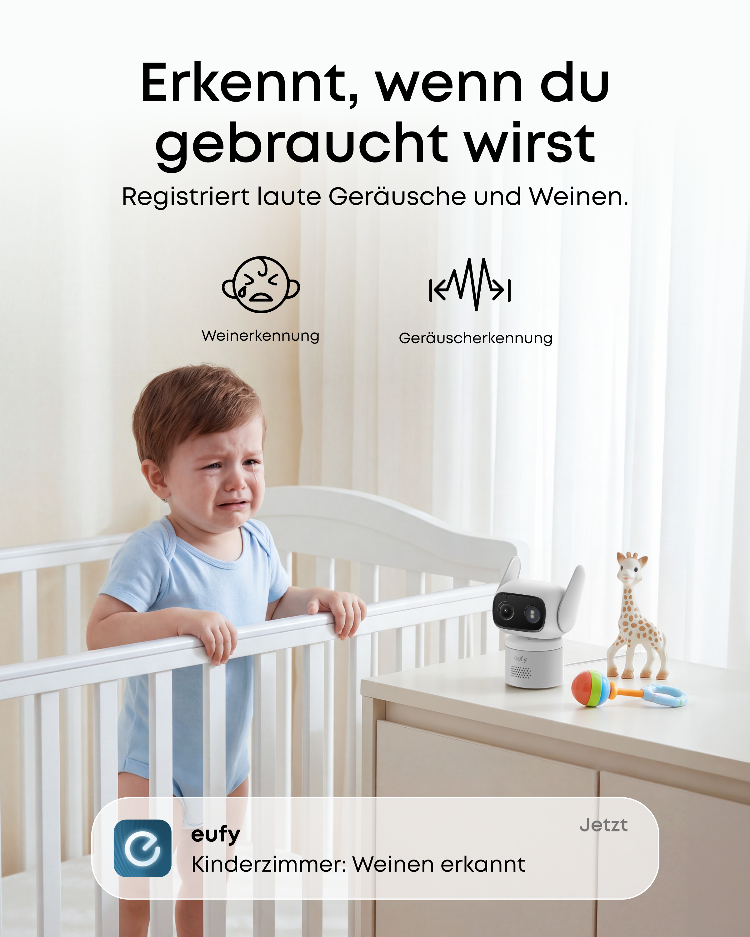 Ein weinendes Baby im Kinderbett mit einem Babyphone auf dem Nachttisch.