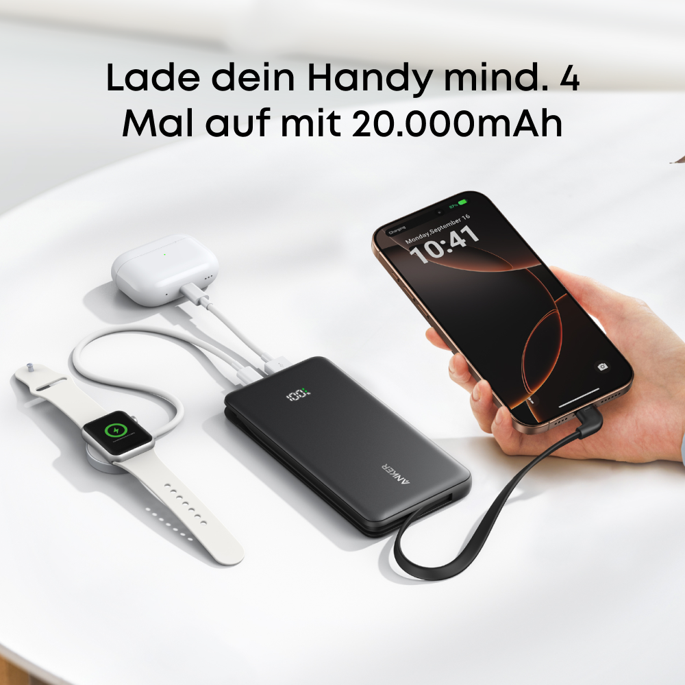 Schwarzes Powerbank lädt Handy, Uhr und Kopfhörer. 100% Ladung.