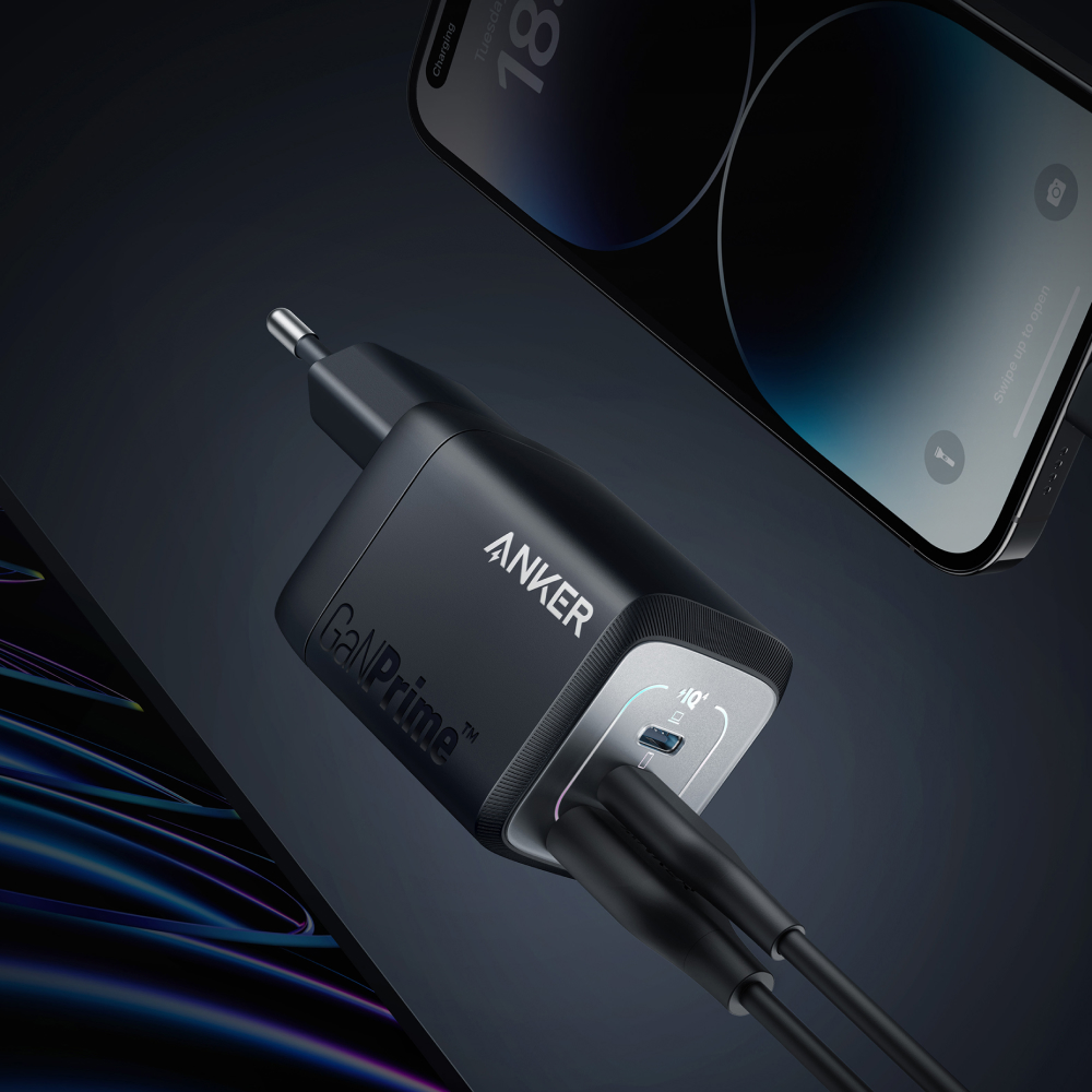 Schwarzes Anker GaNPrime Ladegerät mit zwei USB-C-Anschlüssen, an ein Telefon angeschlossen.