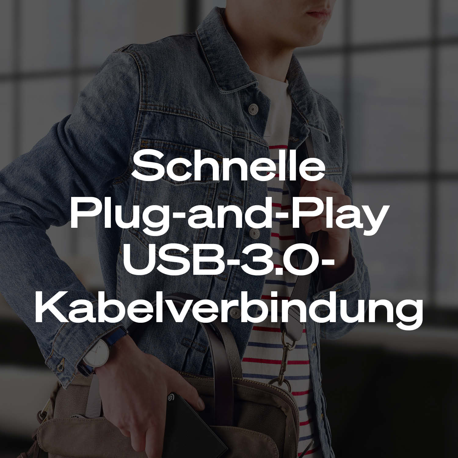Mann mit Jeansjacke und gestreiftem Hemd, hält ein schwarzes Gerät.
