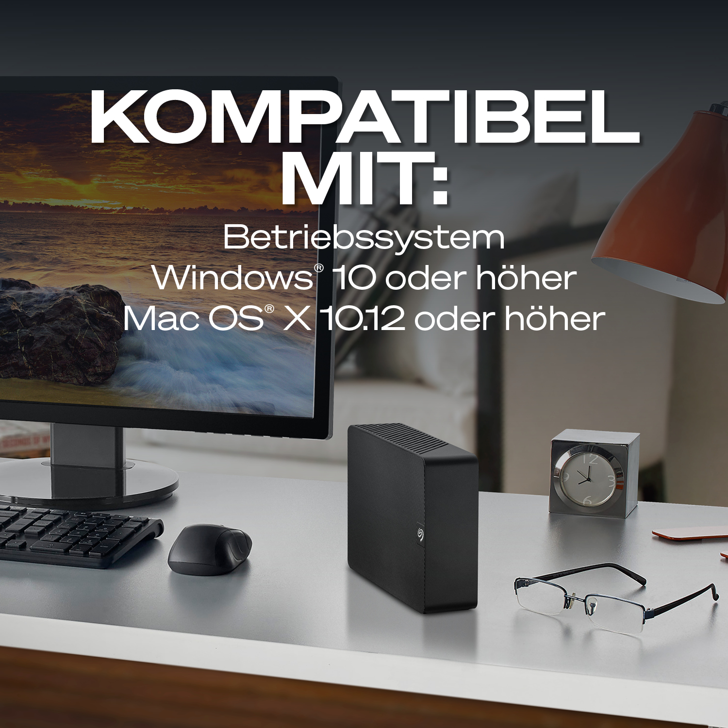 Schreibtisch mit Computer, externer Festplatte, Maus, Tastatur und Uhr.