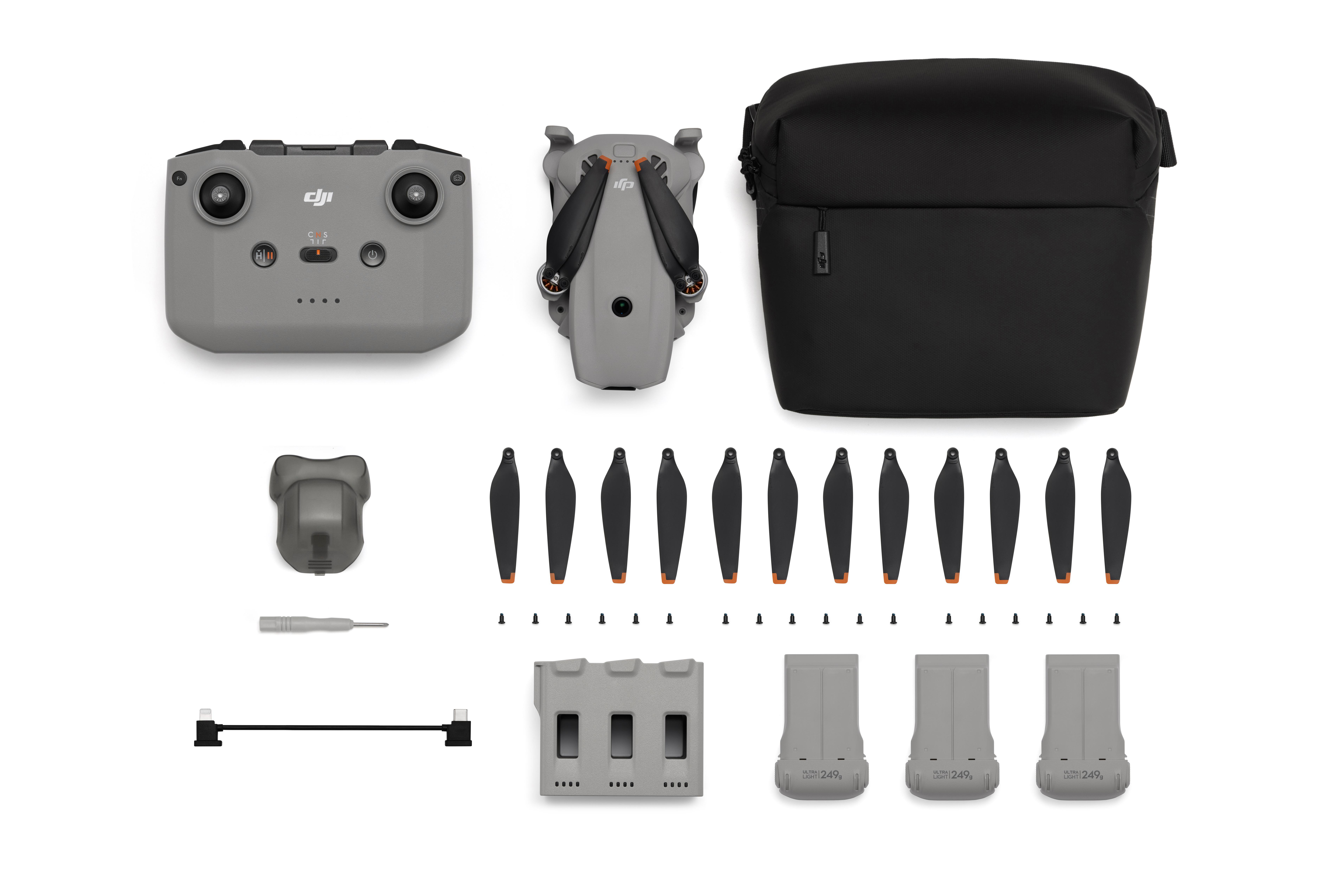 Grauer faltbarer Drohnenkasten mit Fernbedienung, Ersatzpropellern und Batterien.