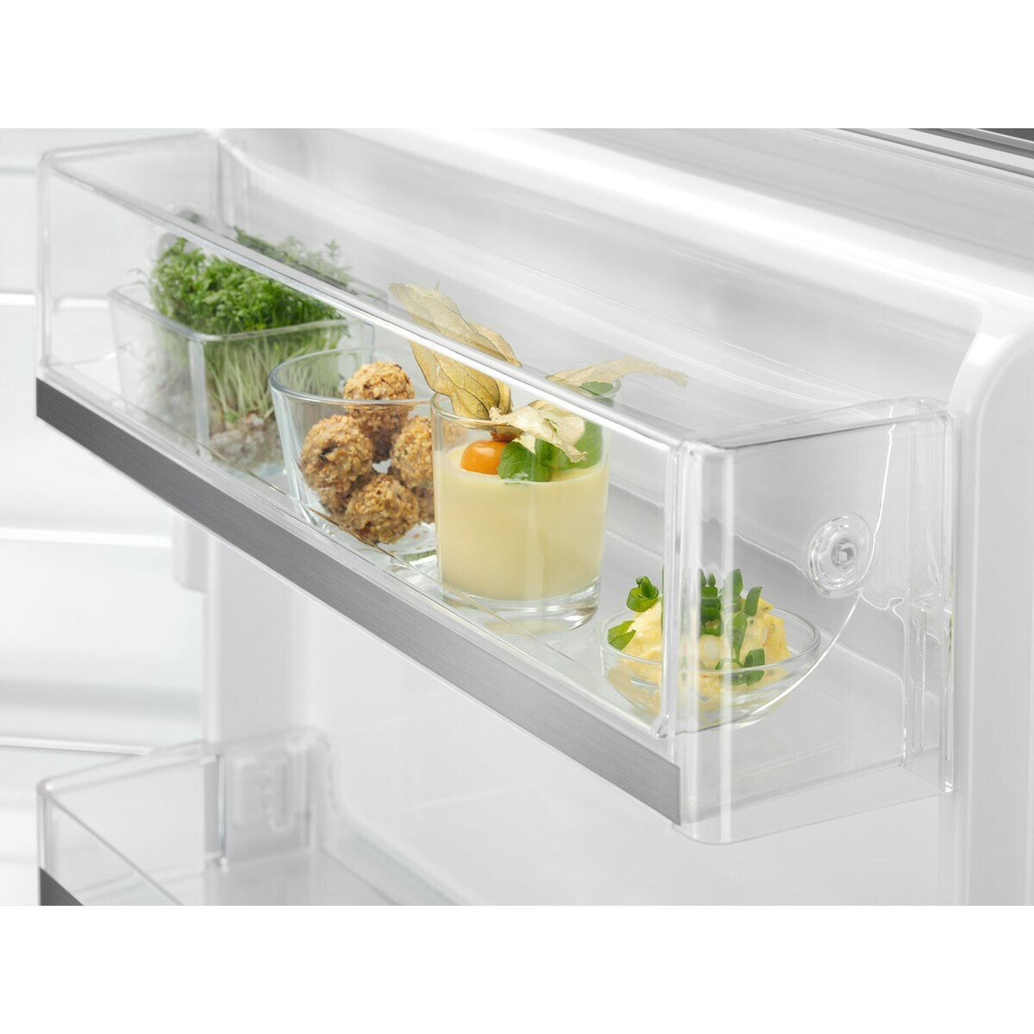 Un contenitore trasparente per frigorifero con mini snack al formaggio, panini e insalata.