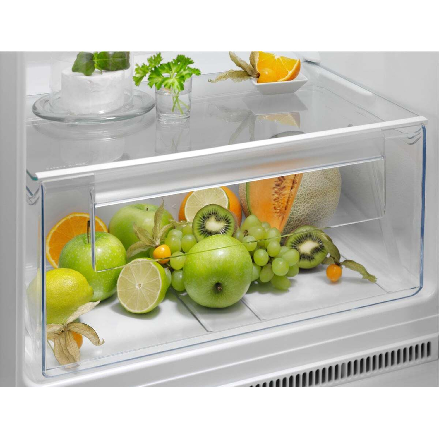 Frutta in un cassetto del frigorifero: mele, kiwi, uva, arance, melone.