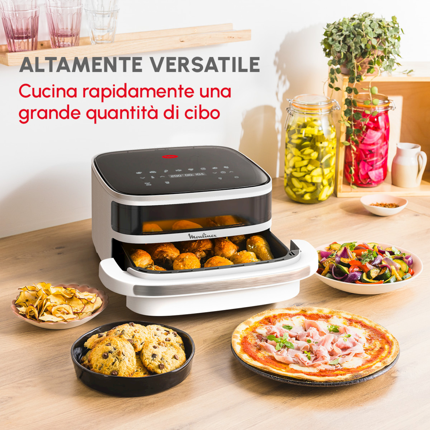 Una friggitrice ad aria con cibo: pizza, biscotti, patatine, verdure e arrosto.