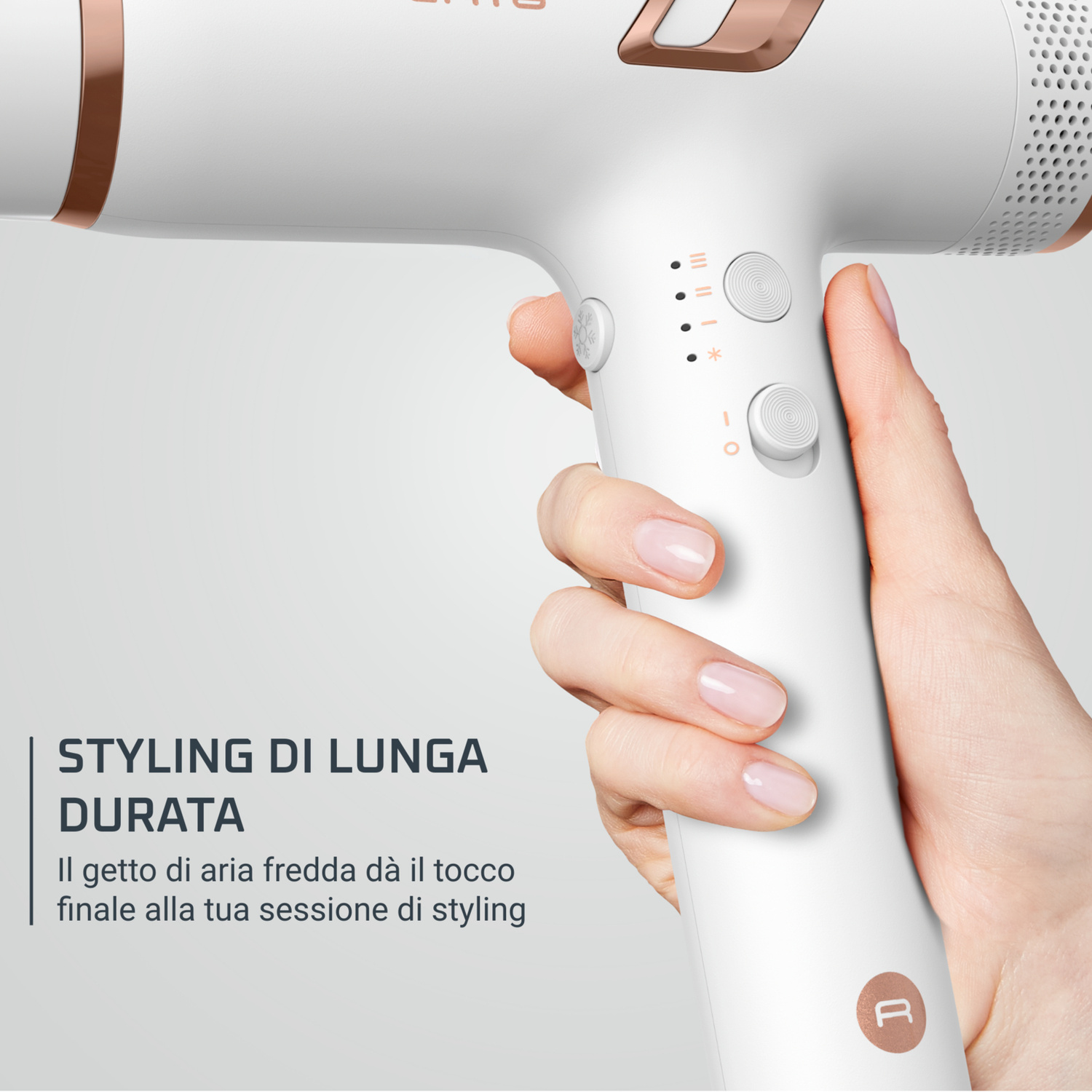 Una mano tiene un asciugacapelli bianco con accenti oro rosa e controlli.