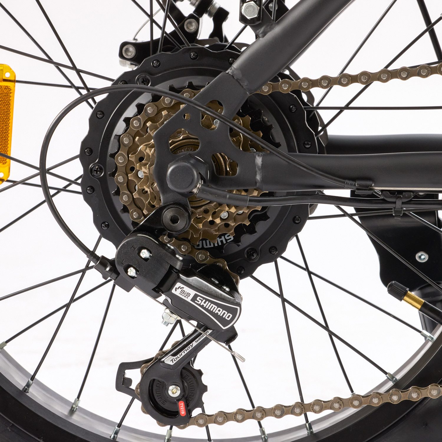 Primo piano di un deragliatore per bicicletta con catena e ingranaggi dorati.