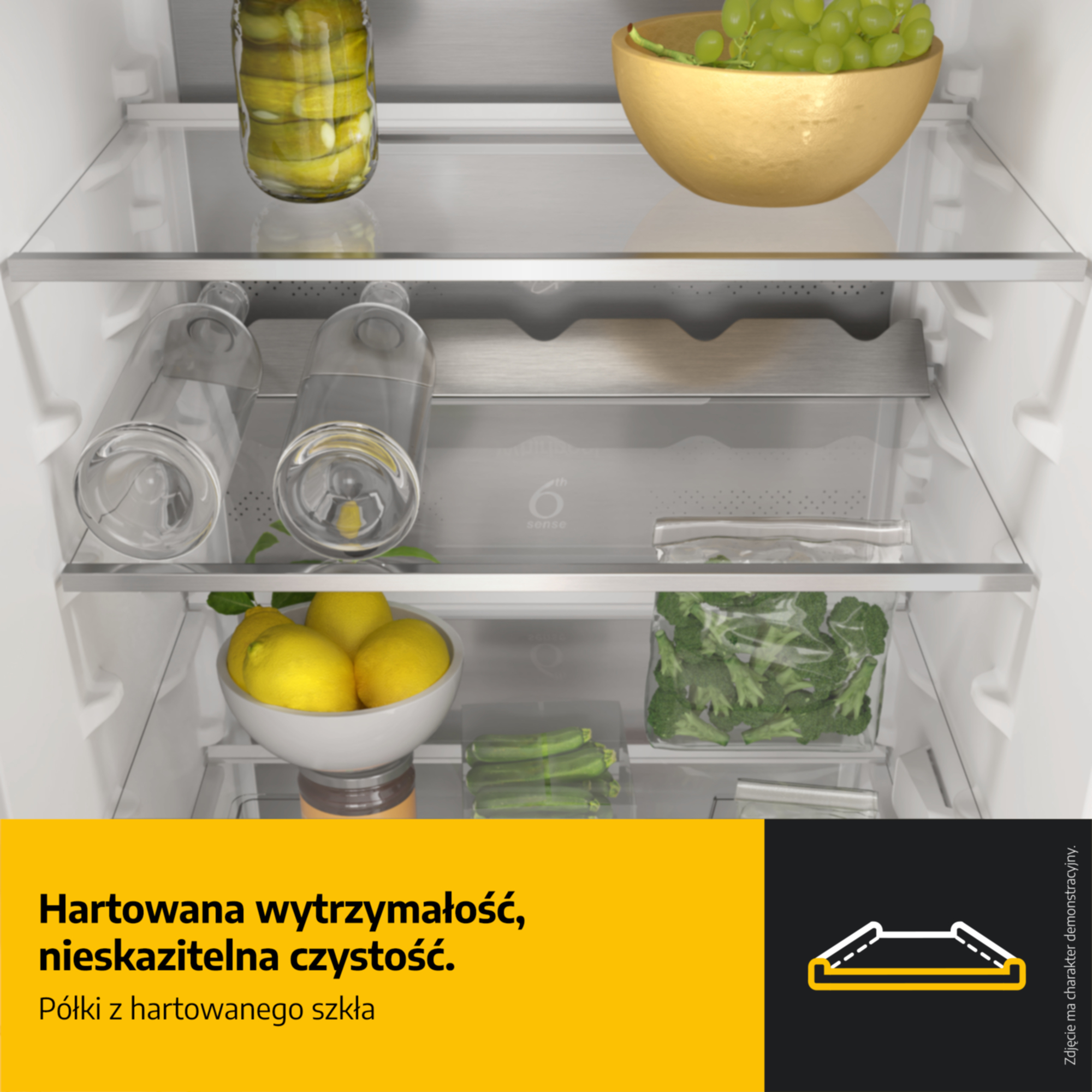 Wypełnione półki lodówki ogórkami, winogronami, cytrynami i brokułami.