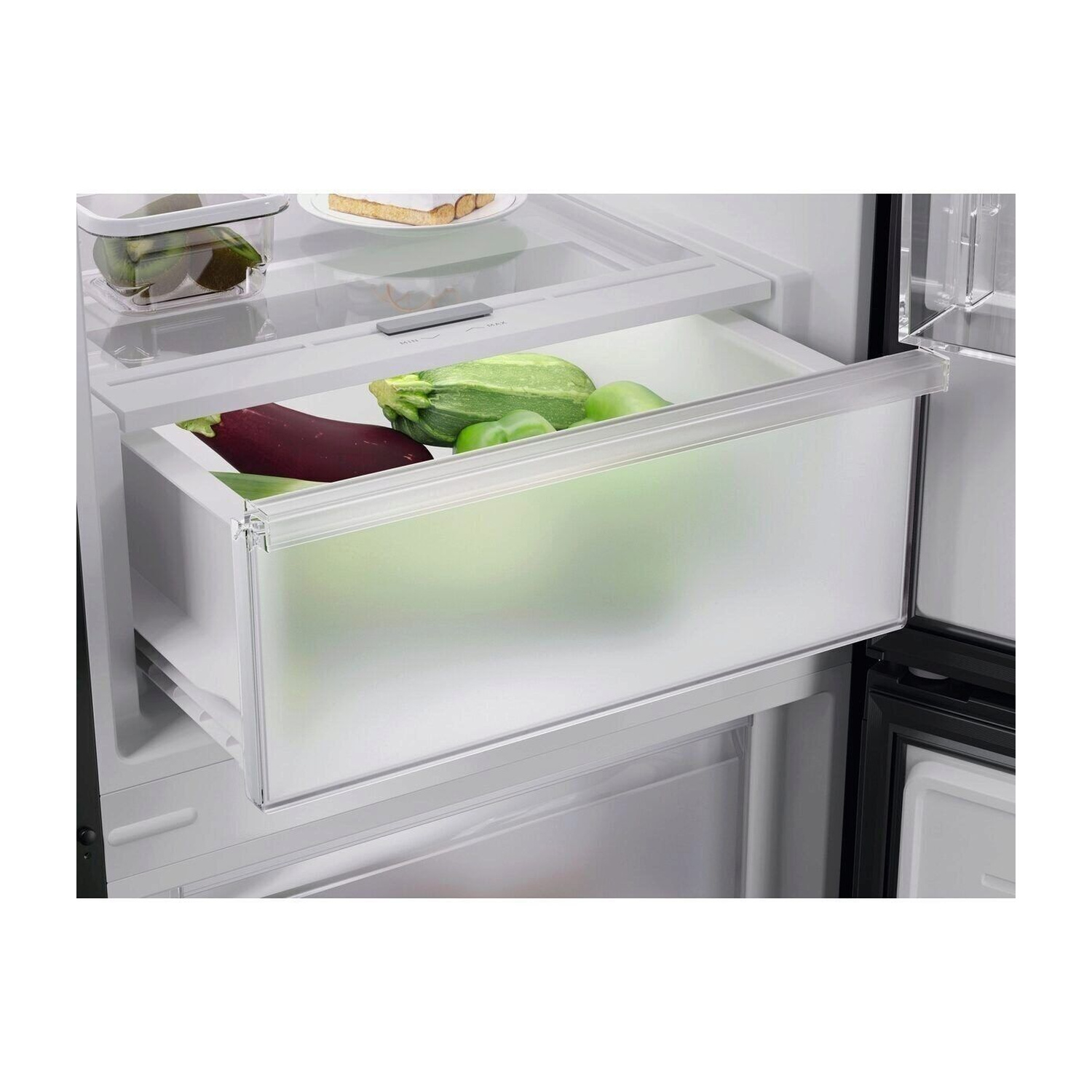 Un cassetto per verdure del frigorifero con melanzane, zucchine e peperoni verdi.