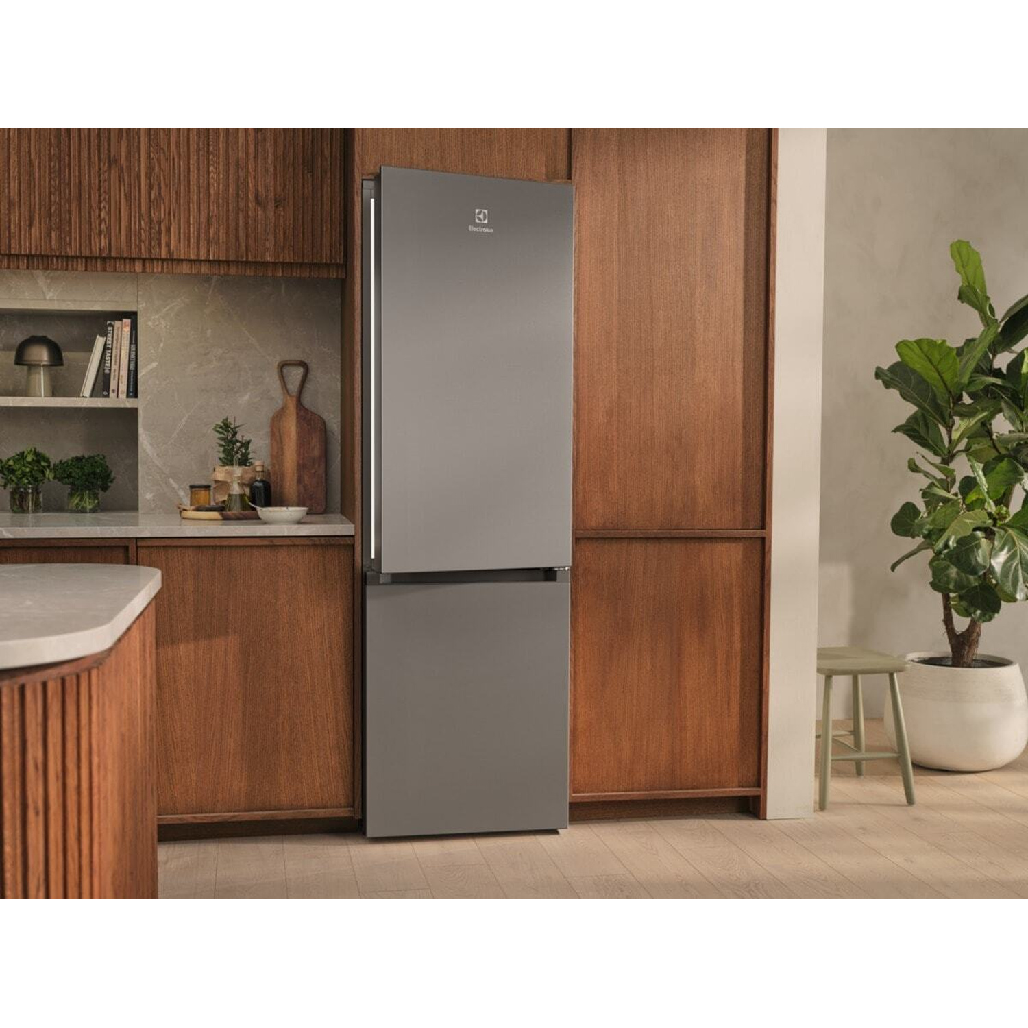 Un frigorifero Electrolux grigio in una cucina moderna con mobili in legno.
