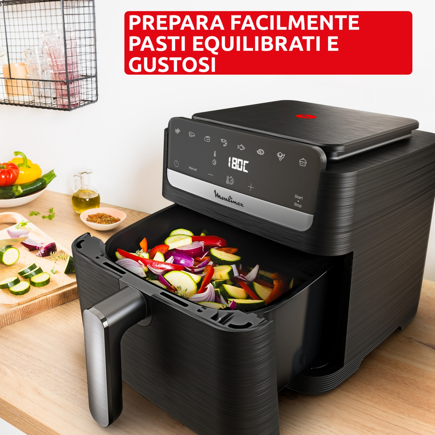 Friggitrice ad aria nera ripiena di verdure tritate come zucchine, cipolle rosse e peperoni.