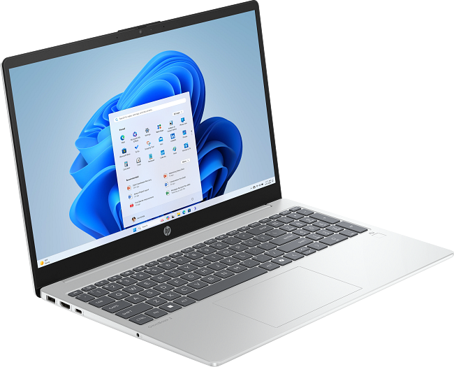 Egy ezüst laptop nyitott képernyővel, amely a Windows 11 startmenüt jeleníti meg.