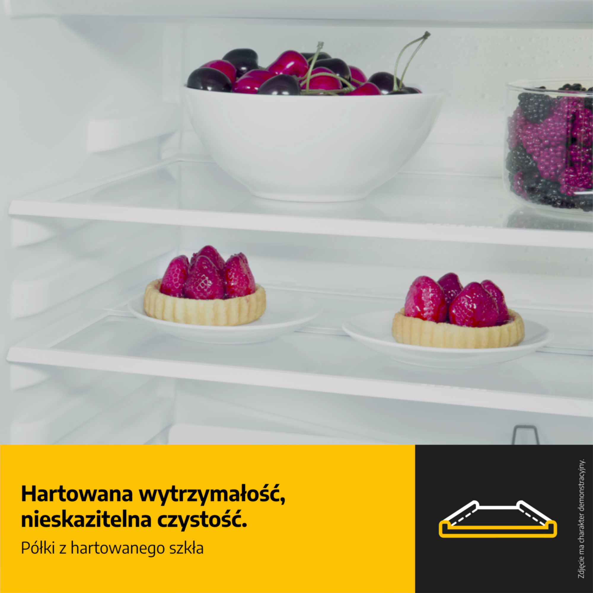 Półka lodówki z wiśniami, jagodami i tartaletkami truskawkowymi.