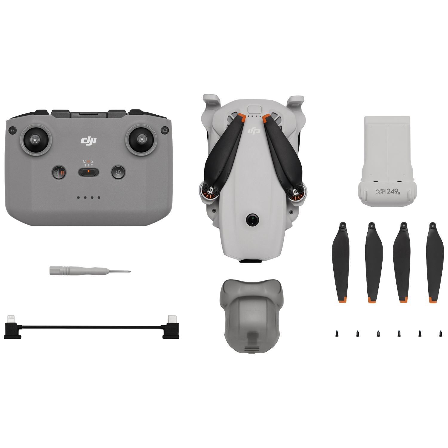 Drone, afstandsbediening, batterij, propellers, schroevendraaier en kabel op wit.