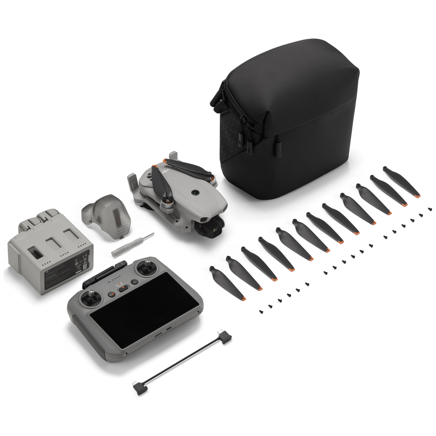 Grijze mini drone kit met reserveonderdelen, controller, tas en gereedschap.